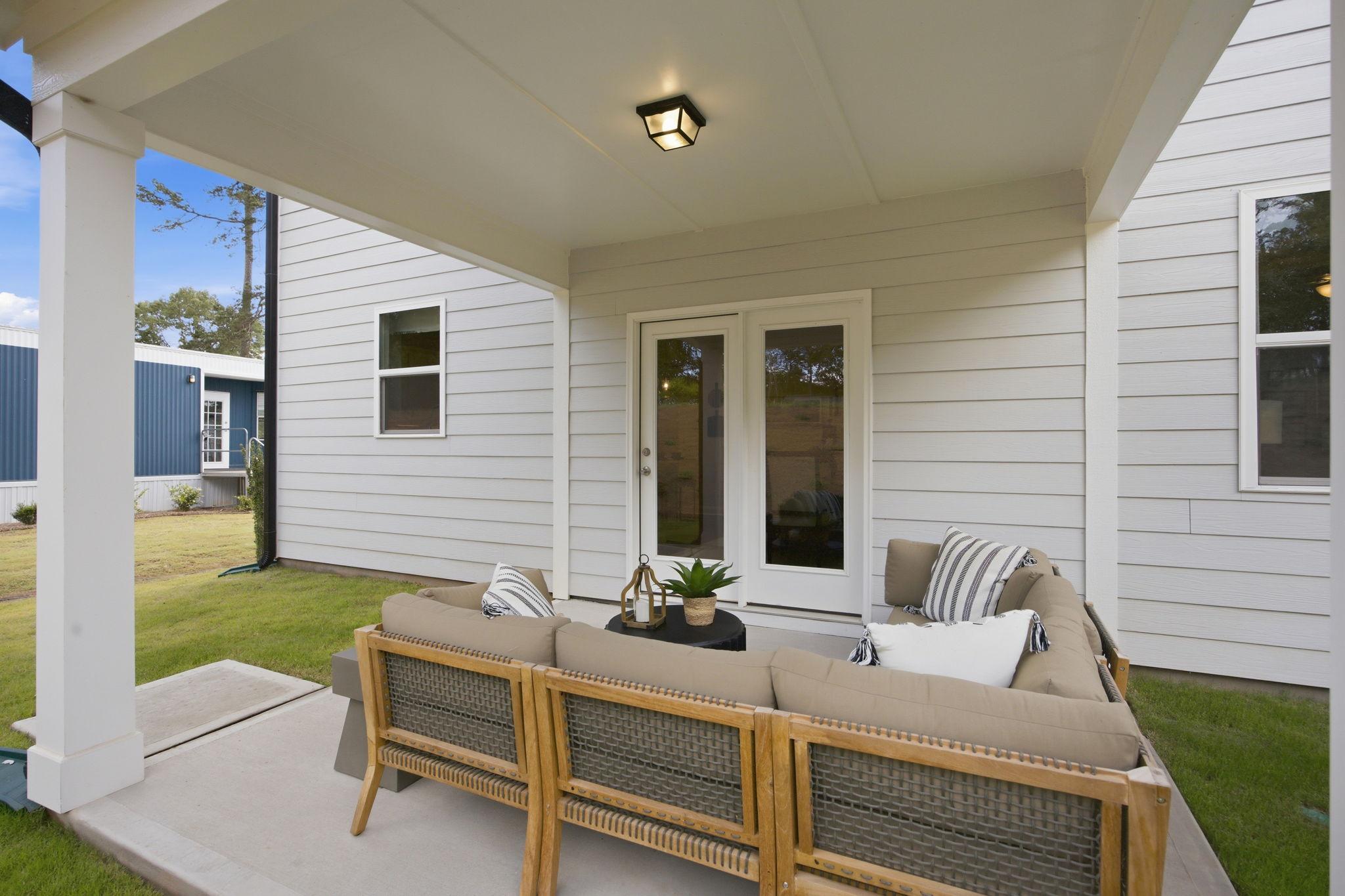 Covered patio with outdoor lounge seating at The Enclave at Belmont in Belmont, NC by Davidson Homes.
