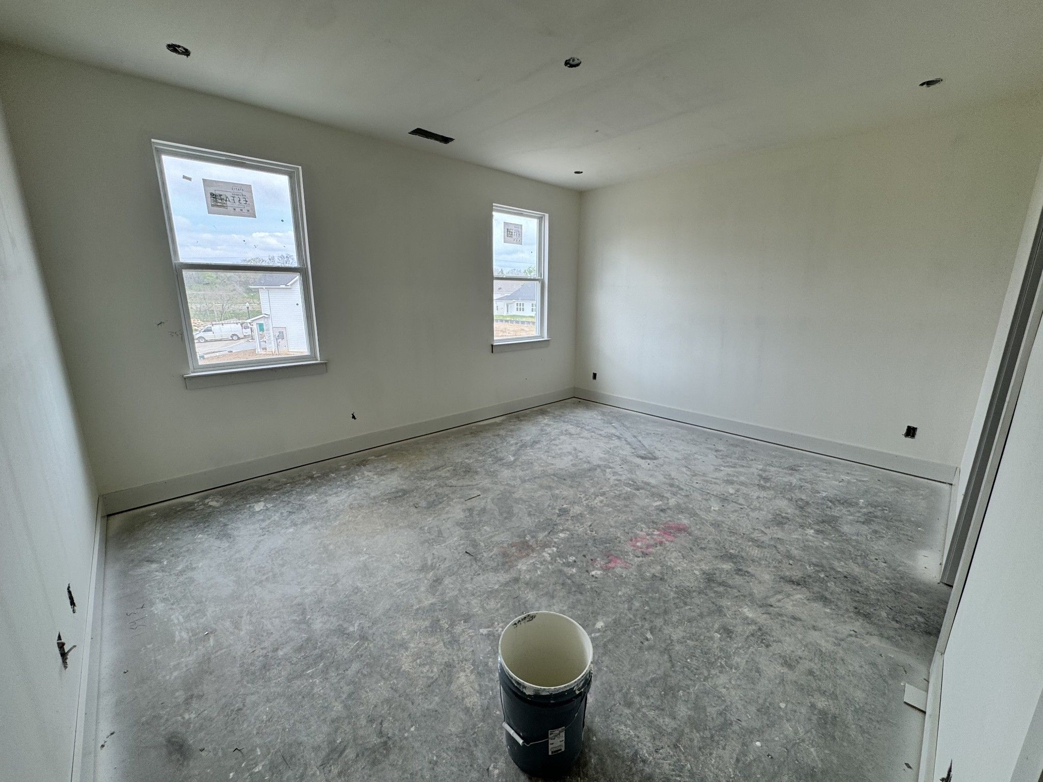 Empty secondary bedroom with double windows, recessed lighting, and unfinished floors in Davidson Homes The Cottonwood E, Gallatin, TN