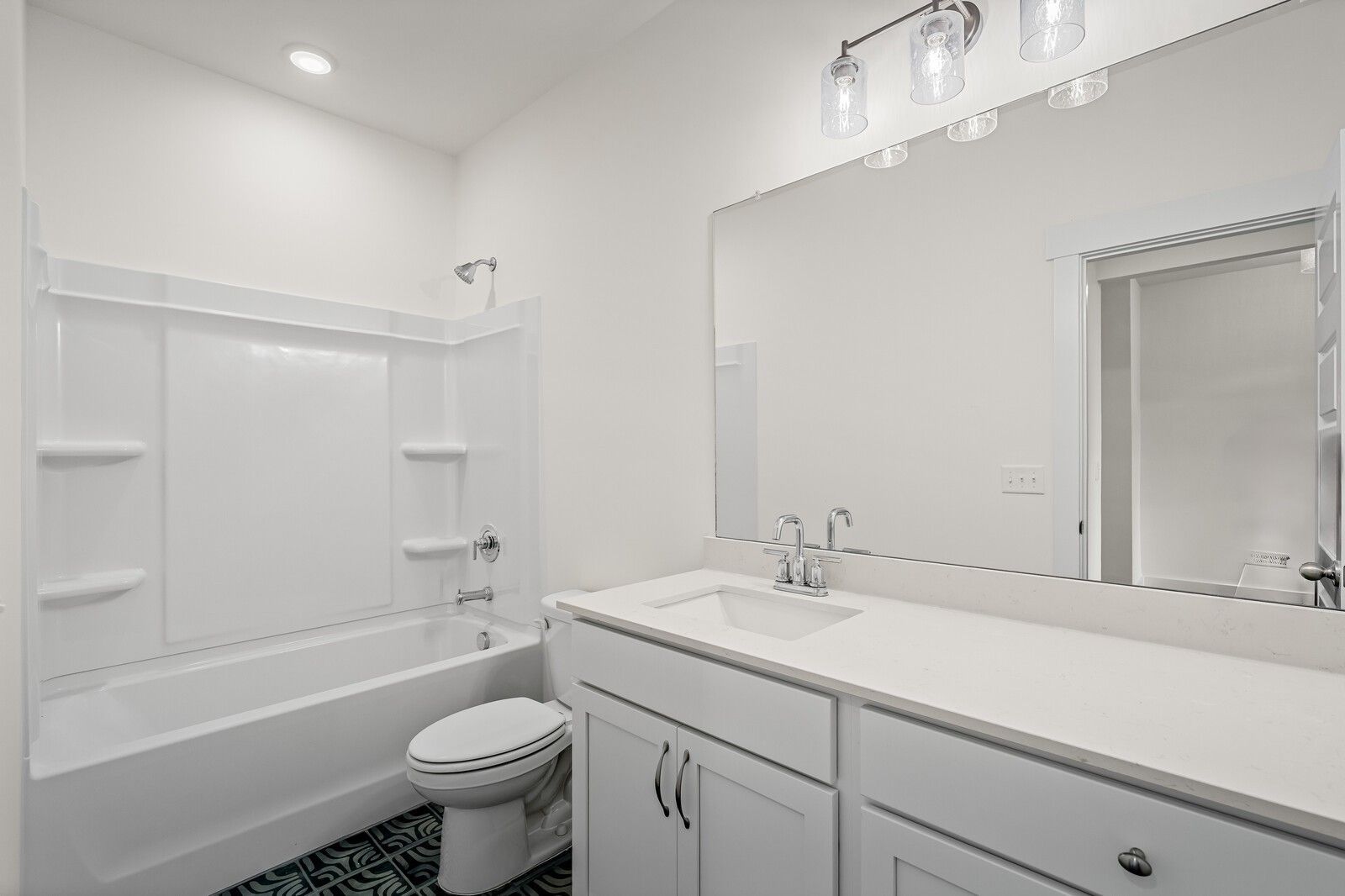 Bright white guest bathroom with tub-shower combo, single vanity sink, and teal patterned tile in Ridgeport D home, Mt. Juliet