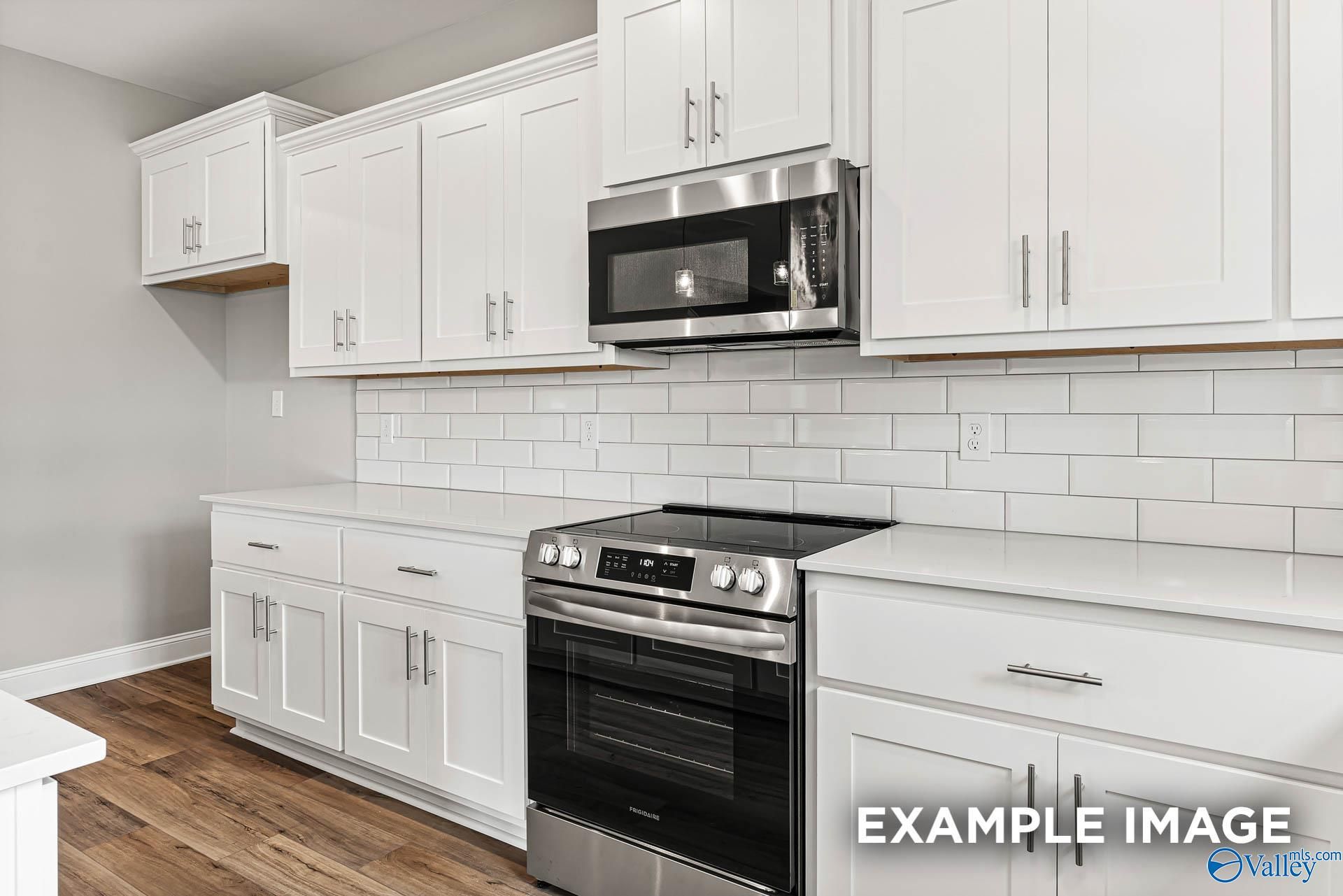 Modern kitchen featuring white shaker cabinets, stainless steel oven, microwave, cooktop, subway tile backsplash in The Chelsea A, Davidson Homes, Athens AL