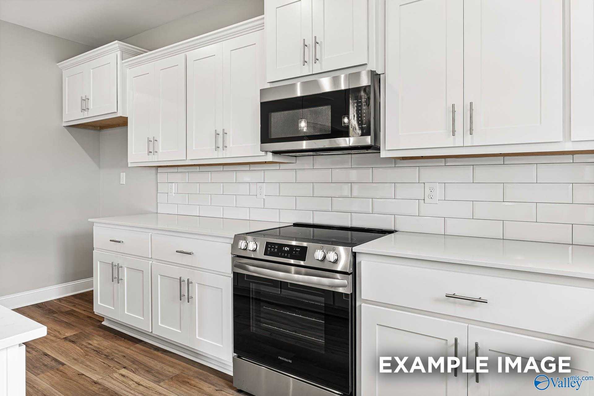 Modern kitchen featuring white shaker cabinets, stainless steel oven, microwave, cooktop, subway tile backsplash in The Chelsea A, Davidson Homes, Athens AL