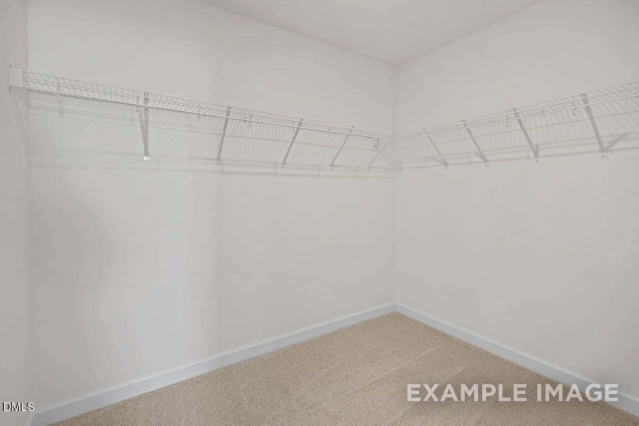 Walk-in closet with white wire shelving in The Graham floor plan by Davidson Homes at Springvale in Fuquay-Varina, NC.