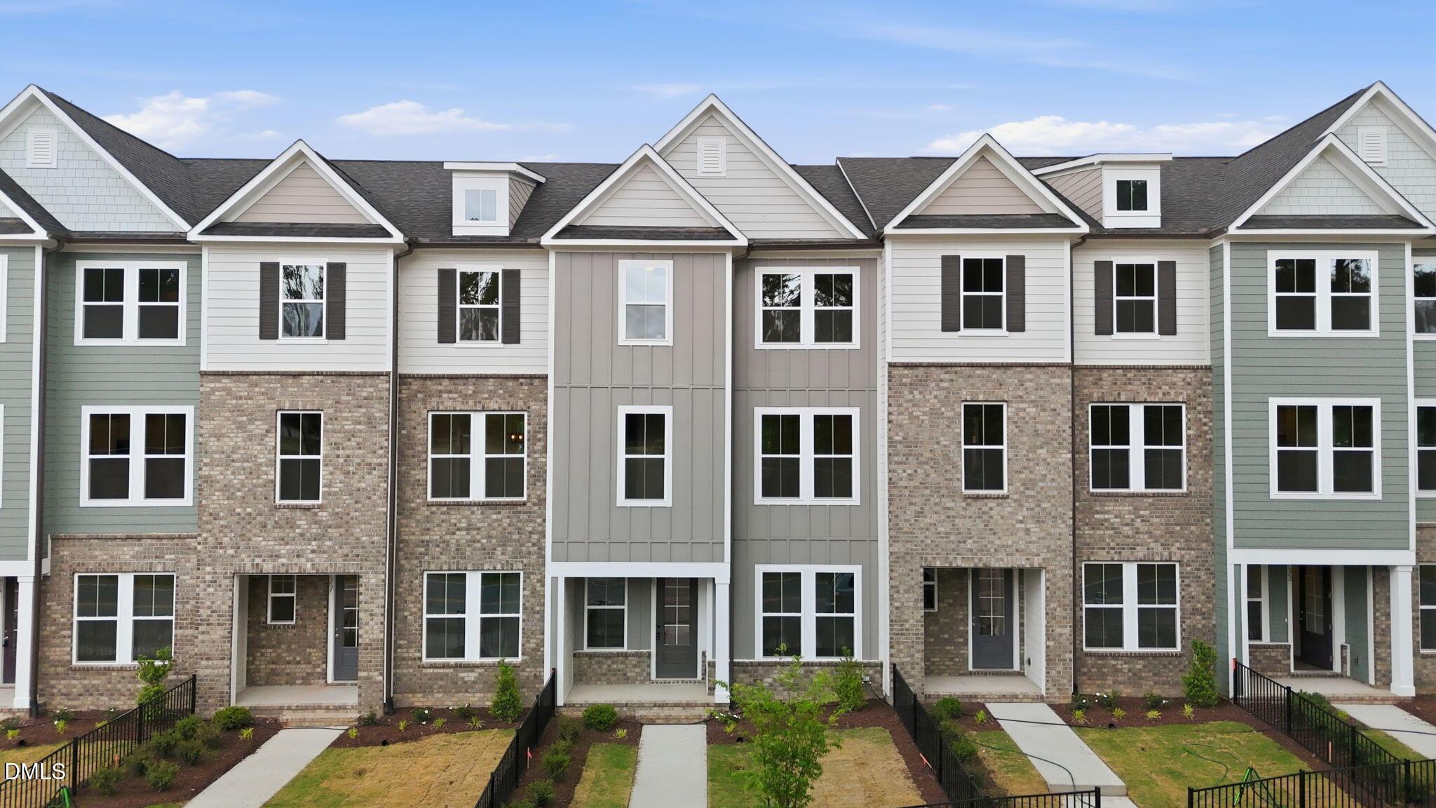 Three-story townhome exterior with brick and siding in The Mitchell Interior floor plan at Camden Park, Knightdale, NC.