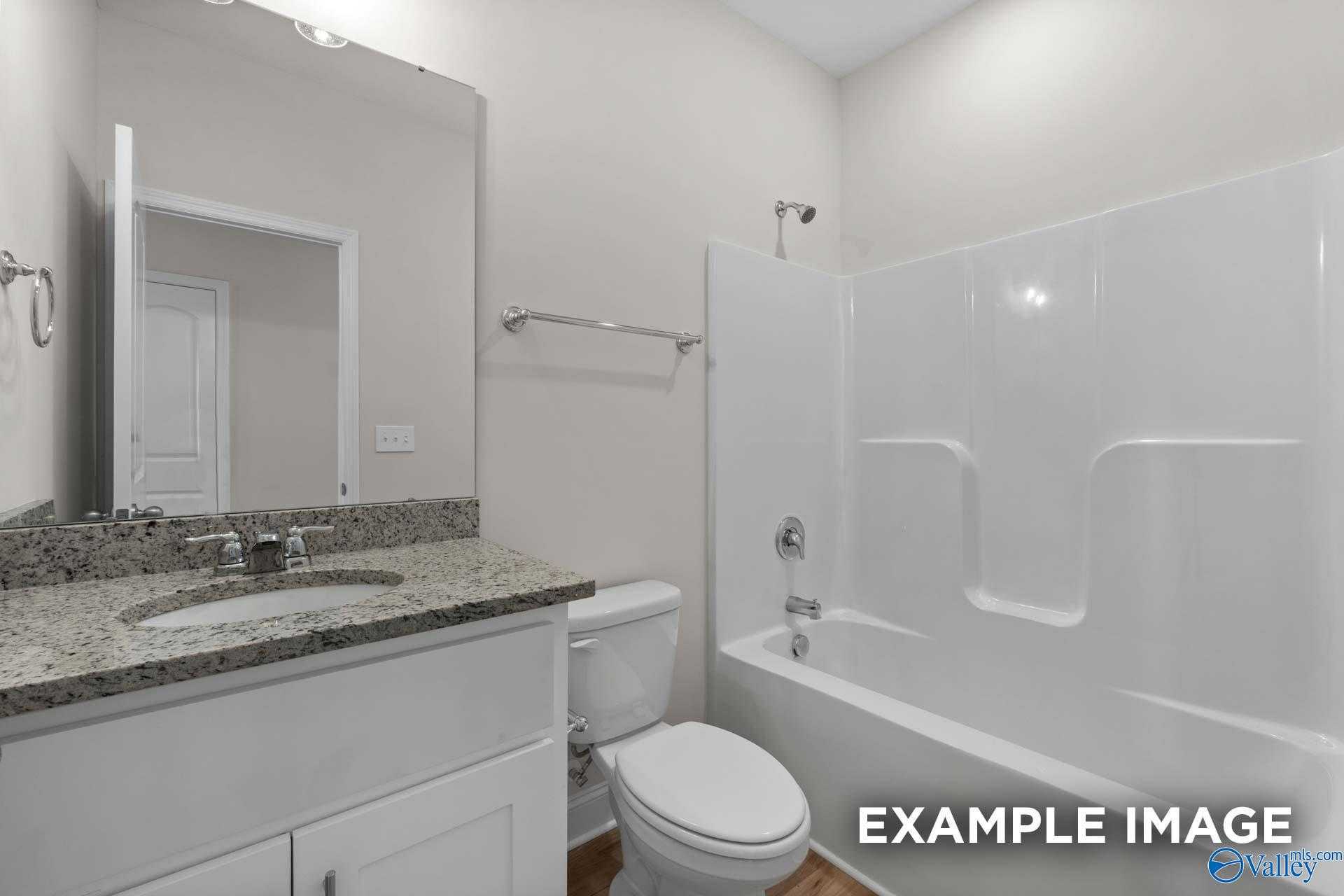 Bright bathroom with granite vanity, walk-in shower, soaking tub, and white fixtures in Davidson Homes The Butler, Toney, Alabama