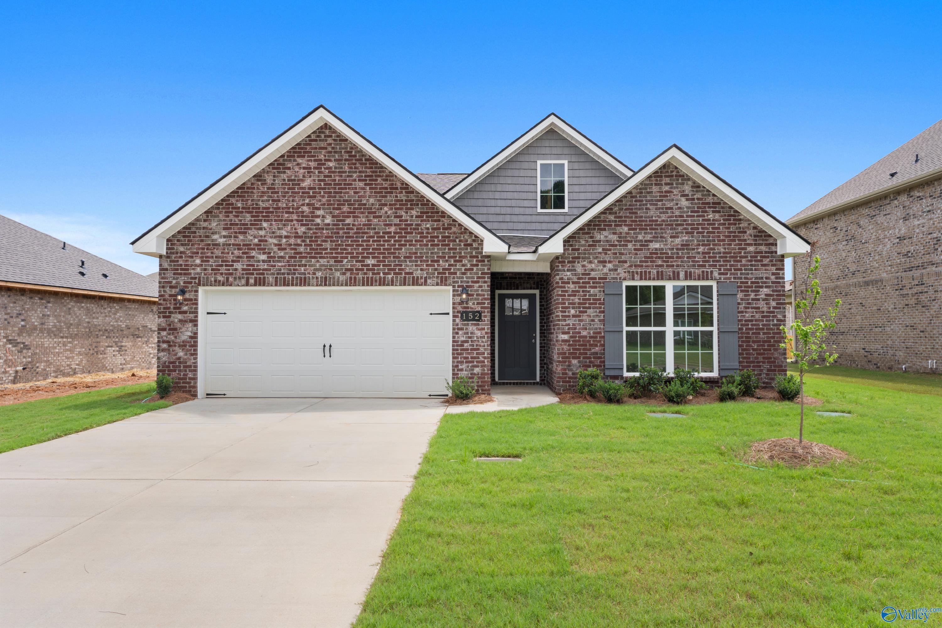 Brick 1-story home with gabled roof, 2-car garage, and lush green lawn in Durham Farms, Harvest, Alabama - Davidson Homes The Franklin C