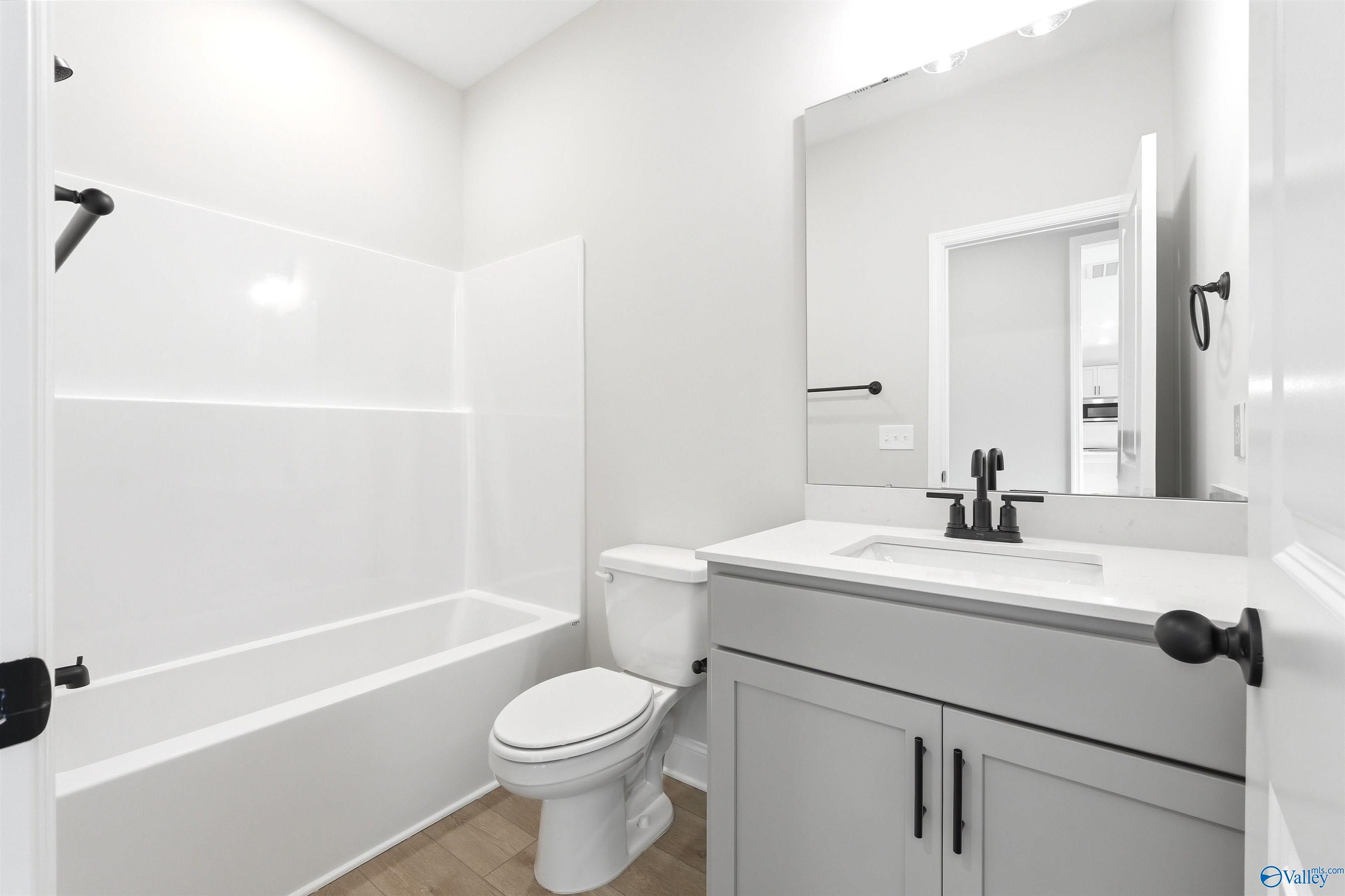 Modern bathroom with vanity, tub-shower combo, and matte black fixtures in The Shelby A floor plan, Wood Trail, Toney, AL.
