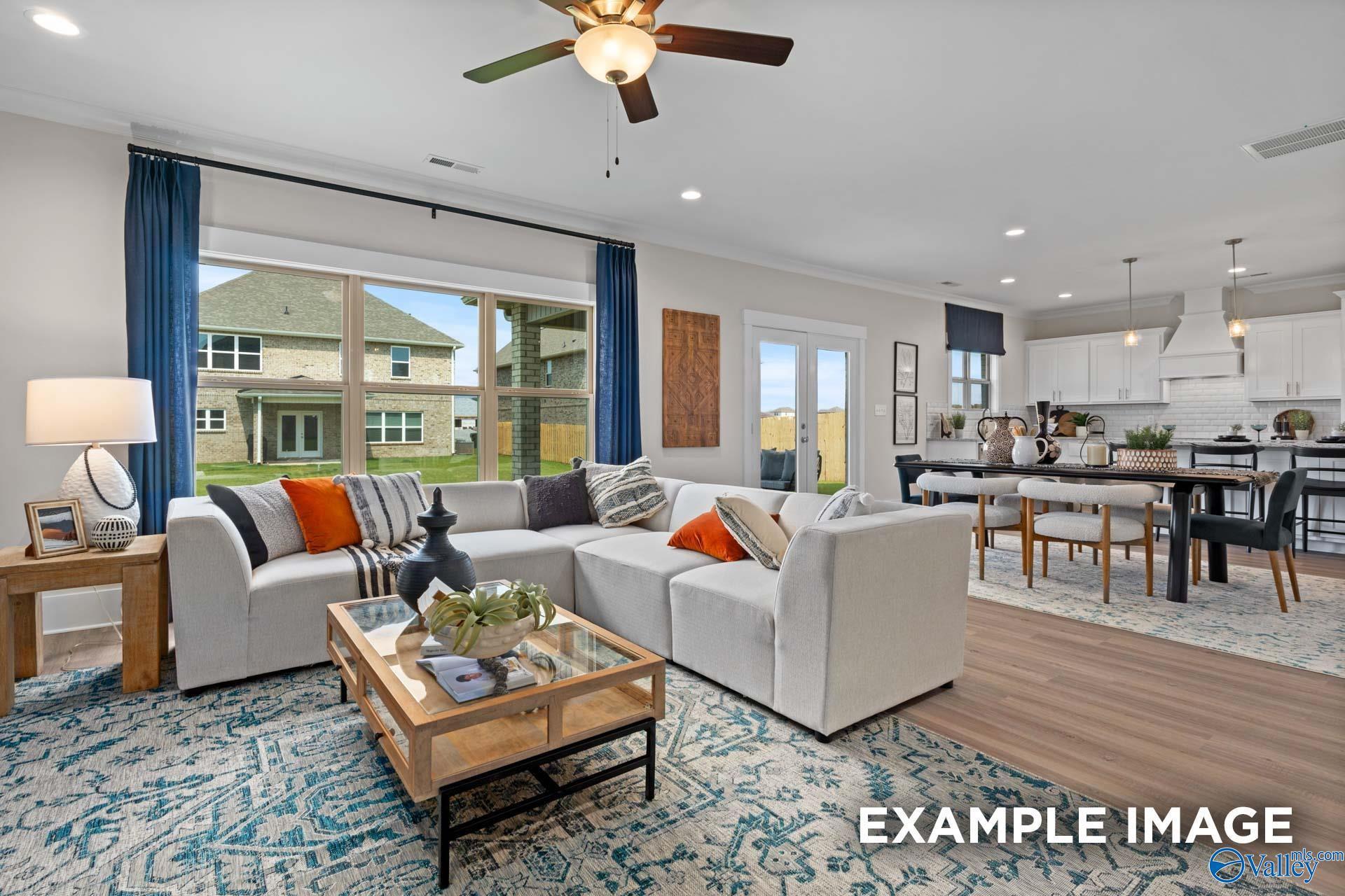 Open-concept living room with sectional sofa and dining area in The Chelsea B floor plan, Ramsay Cove, Owens Cross Roads.
