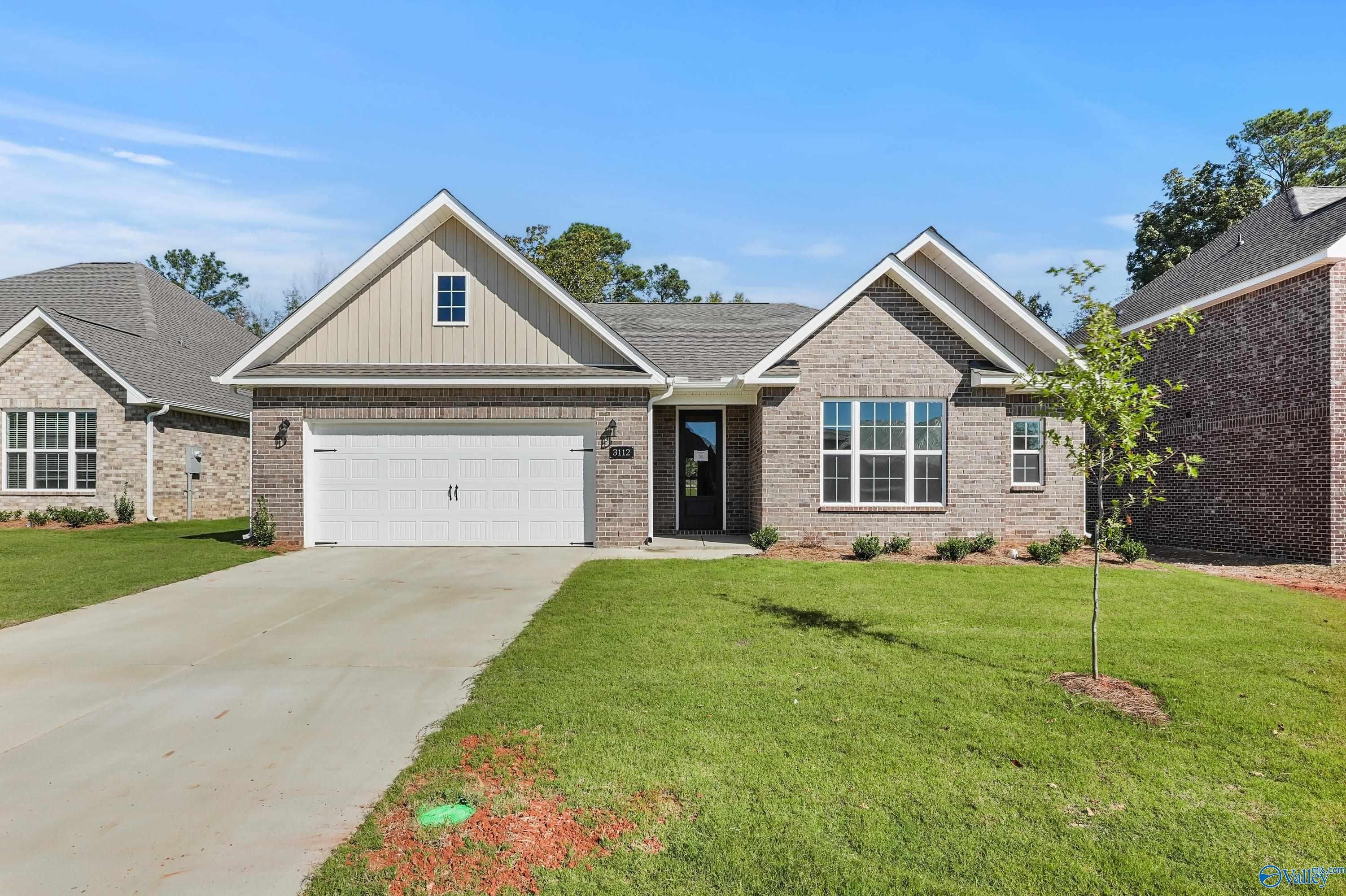 Single-story brick home with 2-car garage, driveway, and landscaped front yard in River Road Estates, Decatur, Alabama