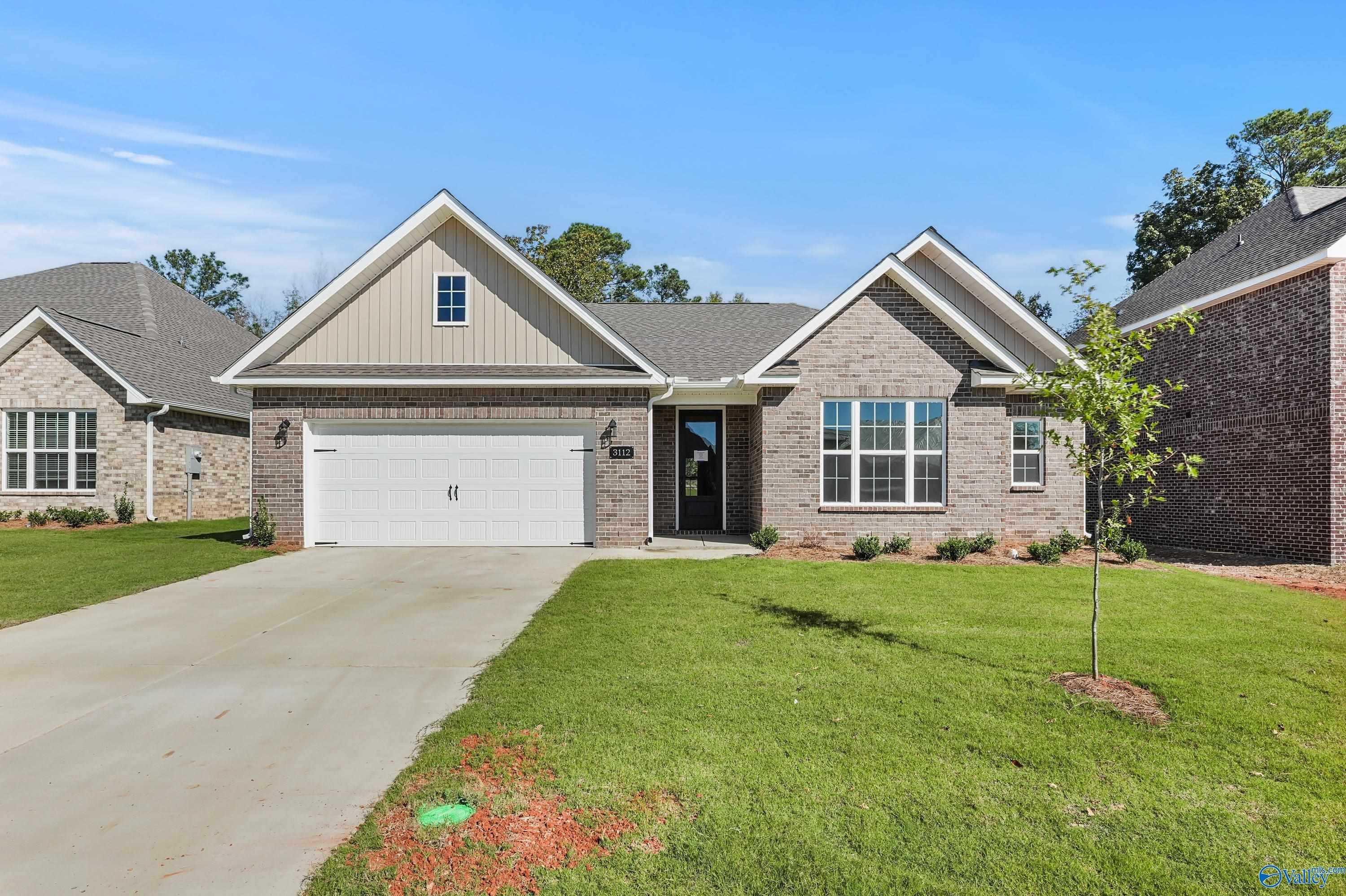 Single-story brick home with 2-car garage, driveway, and landscaped front yard in River Road Estates, Decatur, Alabama