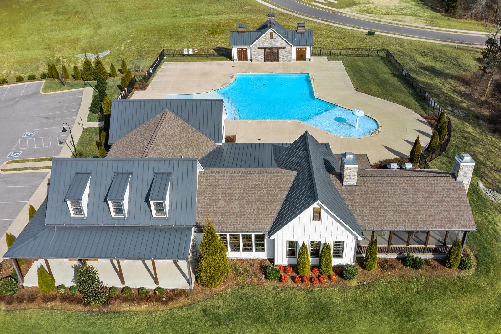Resort-style swimming pool and clubhouse at Carellton in Gallatin TN with metal roofs, cabanas, parking, and lush green landscaping