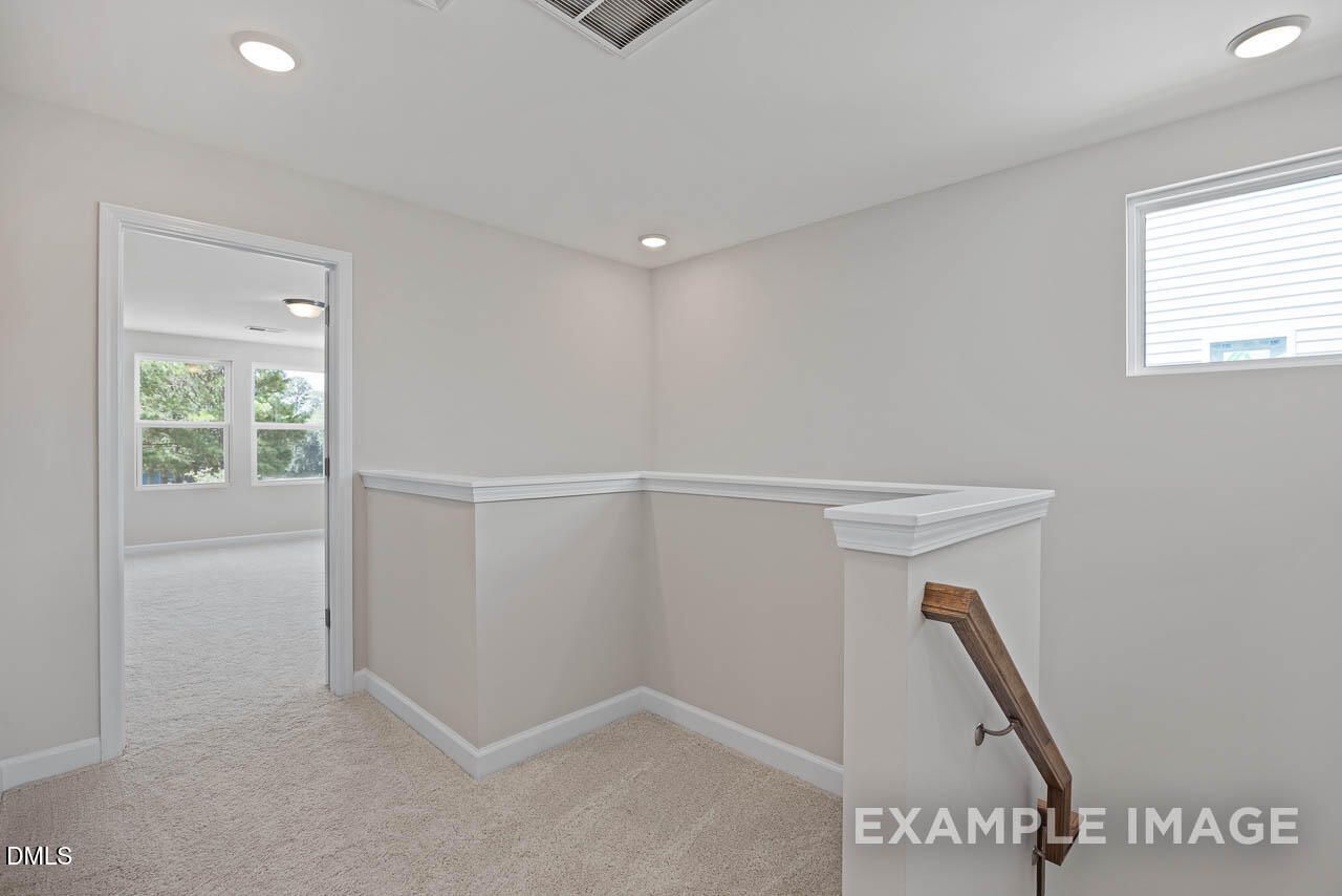 Bright second-floor carpeted landing in The Graham floor plan by Davidson Homes in Springvale, Fuquay-Varina, NC.