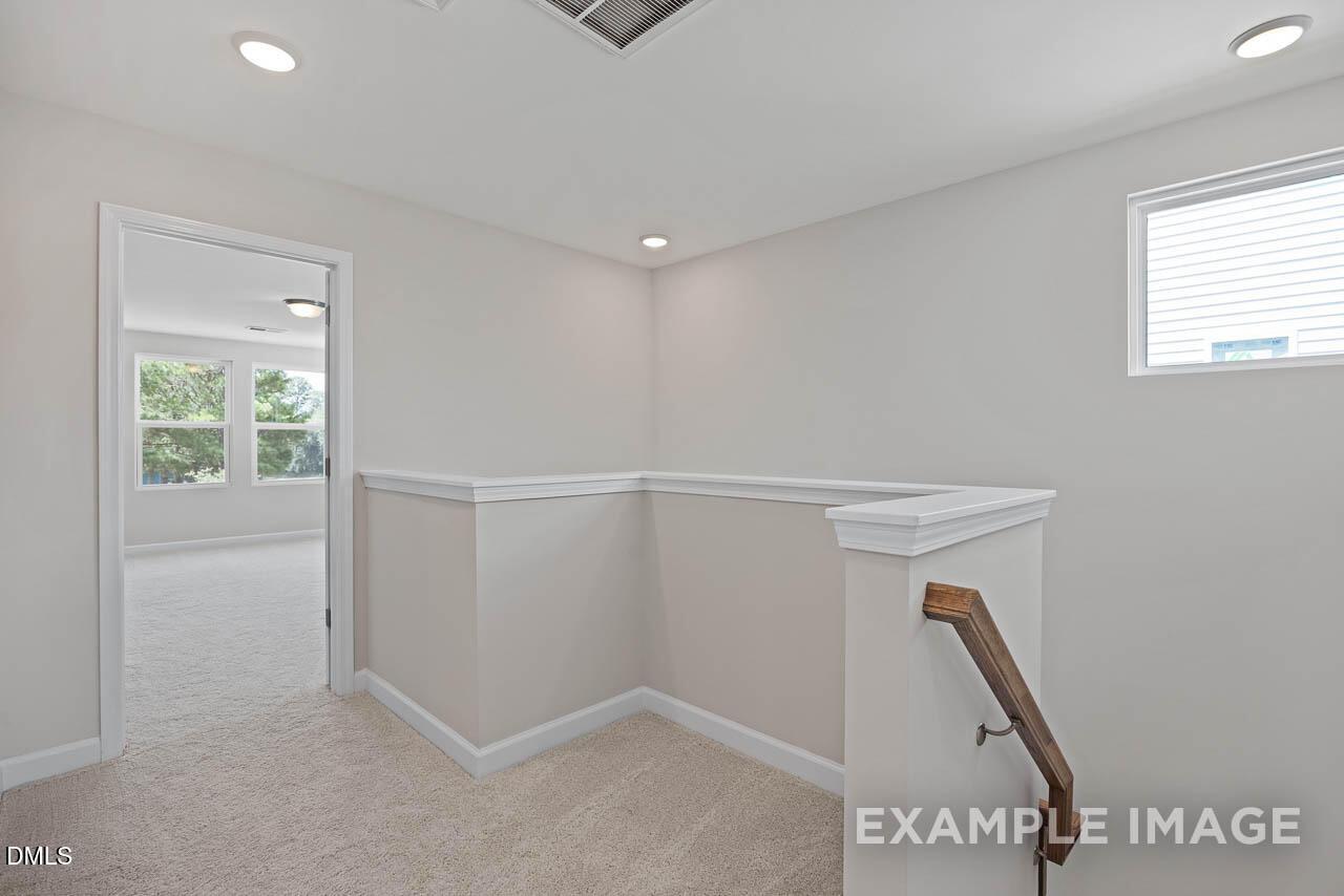 Bright second-floor carpeted landing in The Graham floor plan by Davidson Homes in Springvale, Fuquay-Varina, NC.
