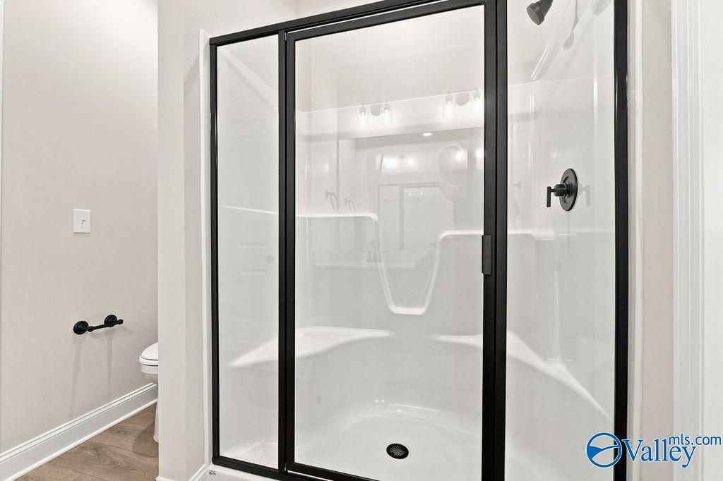 Modern walk-in shower with black frame in The Camilla C floor plan at The Retreat at Cain Park, Hartselle, Alabama.