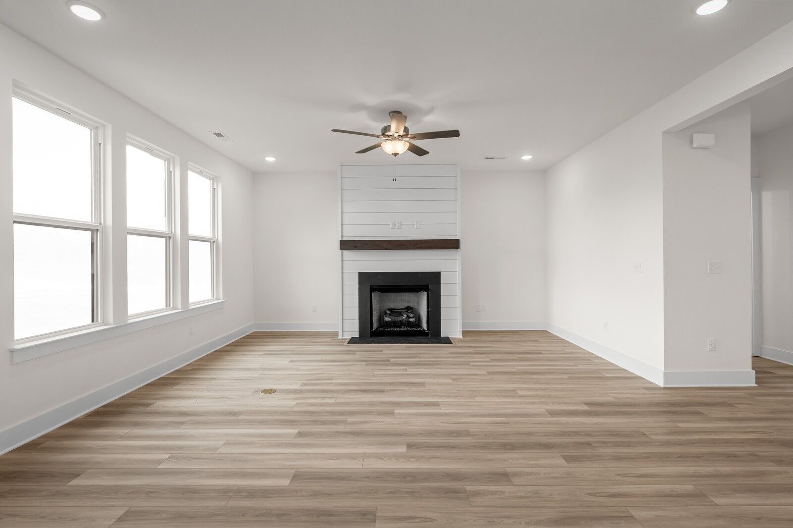 Living room with shiplap fireplace and hardwood floors in The Henry C floor plan by Davidson Homes in Mt. Juliet, Tennessee.
