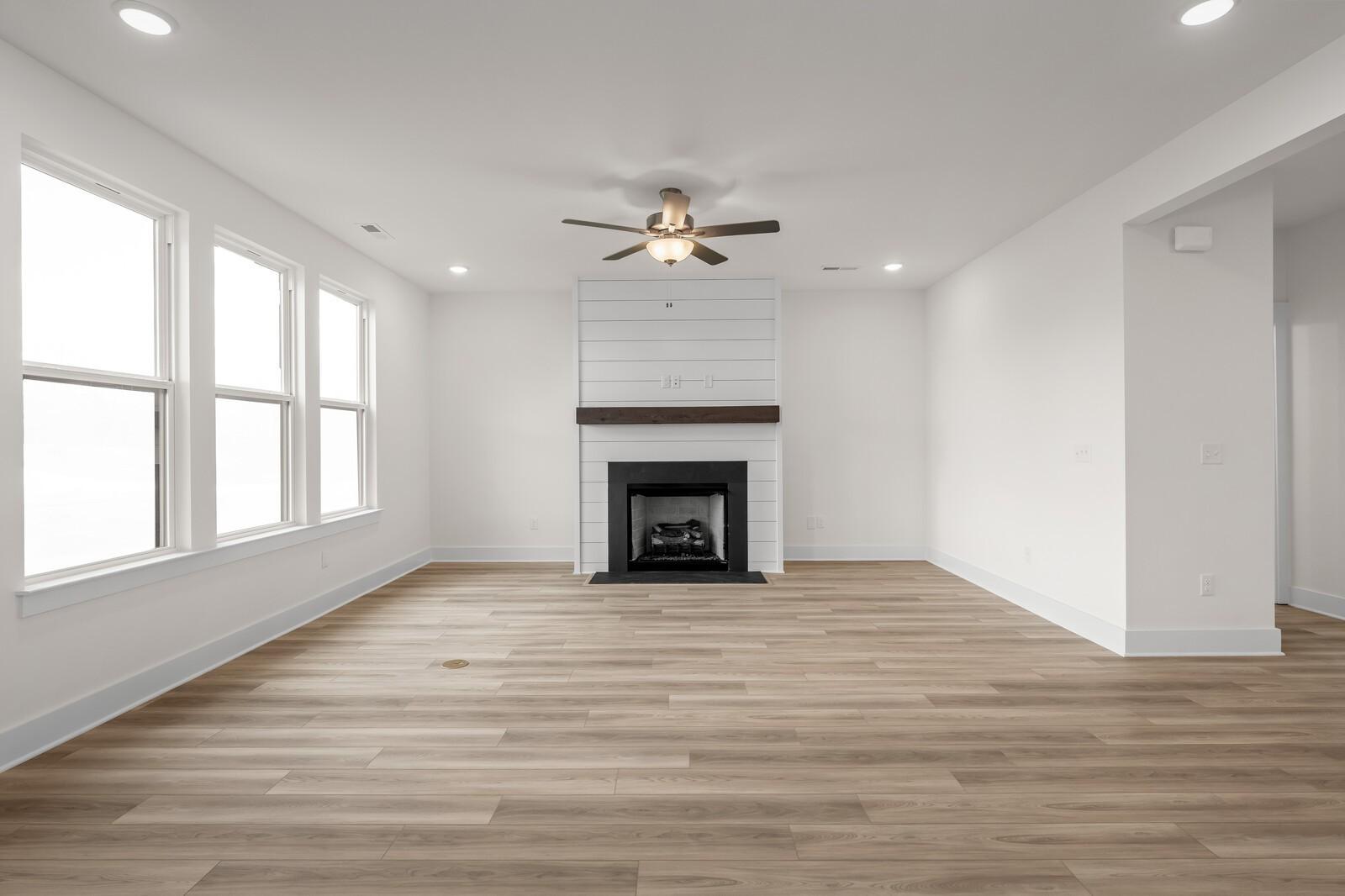 Living room with shiplap fireplace and hardwood floors in The Henry C floor plan by Davidson Homes in Mt. Juliet, Tennessee.