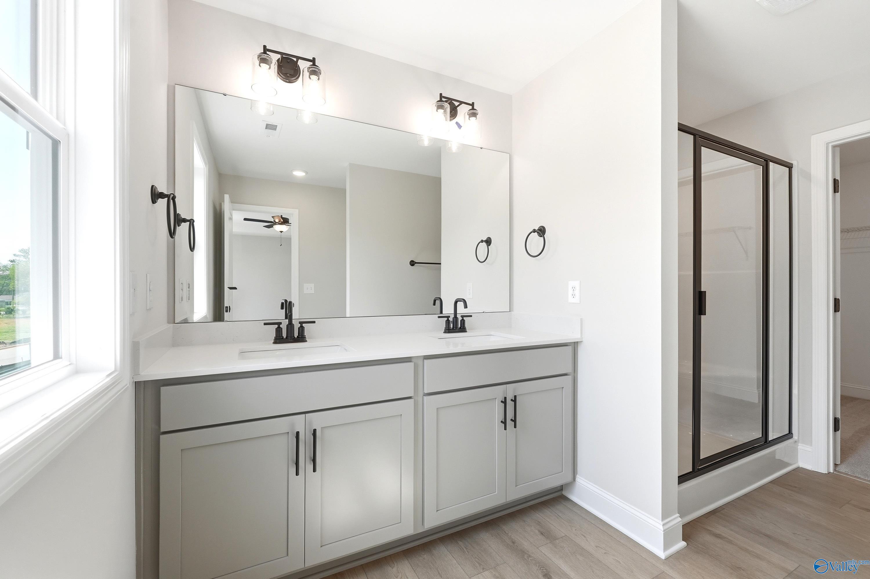 Modern double vanity with gray cabinets and matte black fixtures in The Russell A floor plan, Spragins Cove, Huntsville.