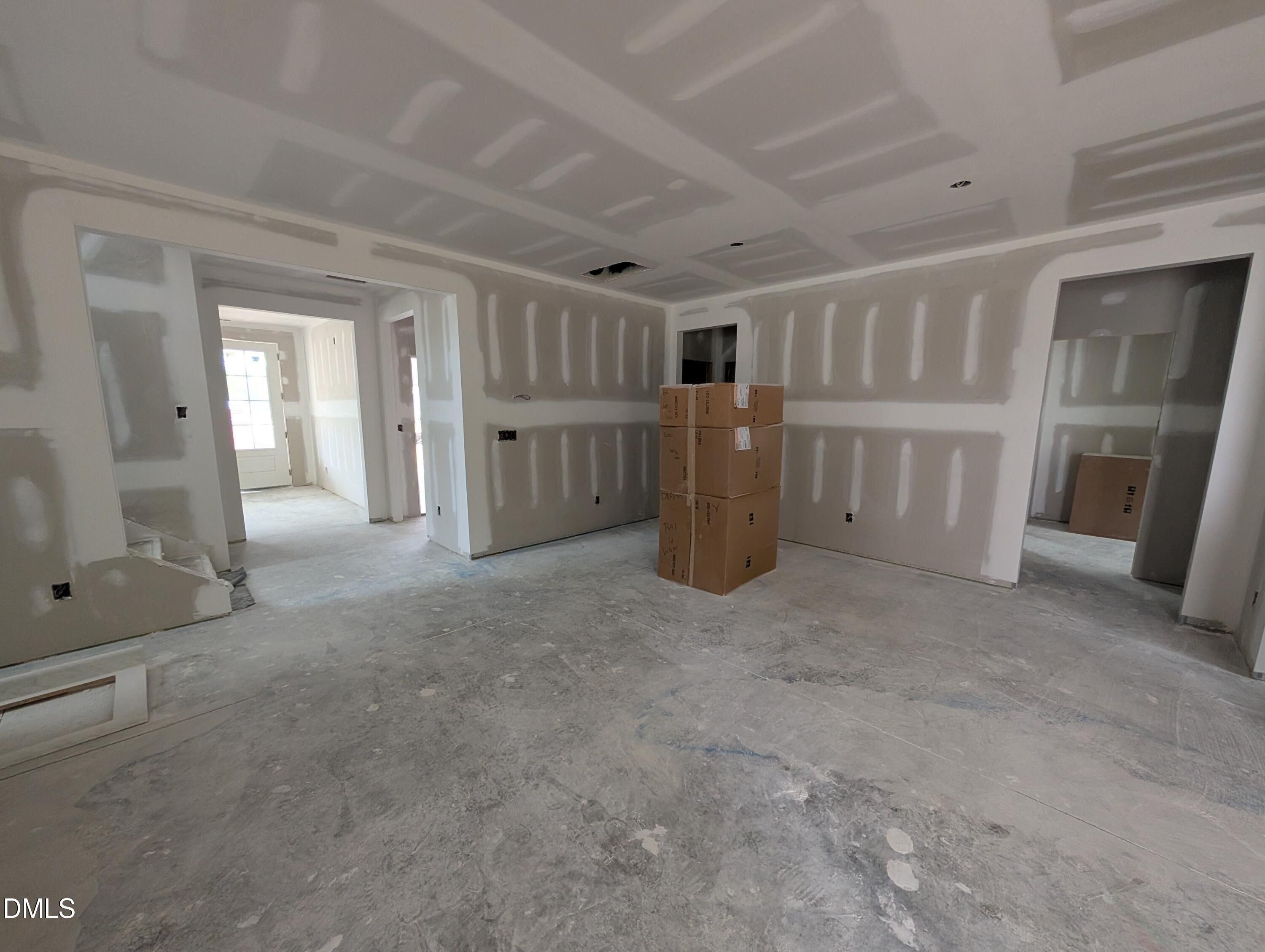 Unfinished open-concept great room with coffered ceiling under construction in Davidson Homes' The Aspen C, Wendell Ridge, Wendell NC