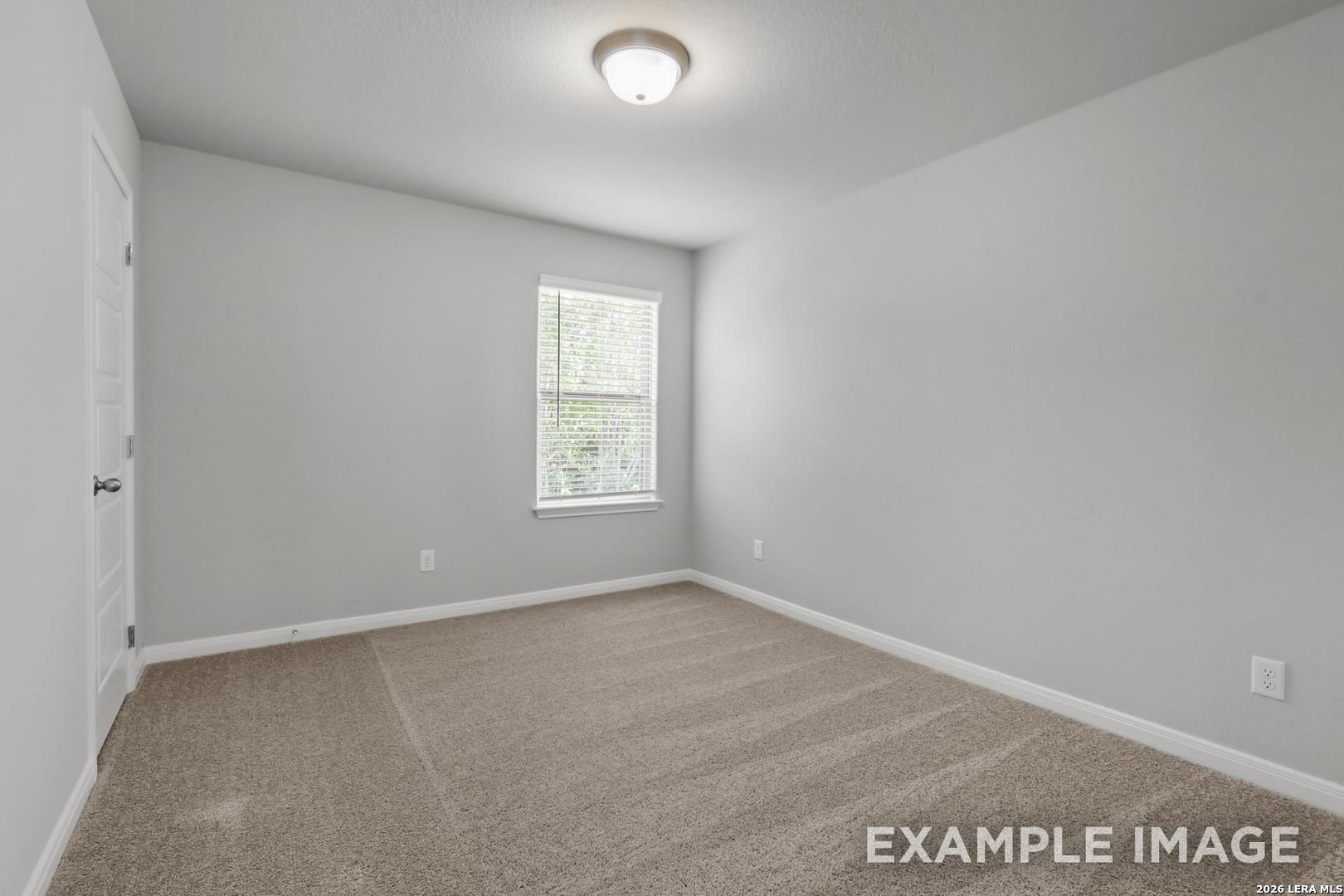 Spacious secondary bedroom with neutral gray walls and plush carpet in The Gillian A floor plan, Cedar Heights, San Antonio.
