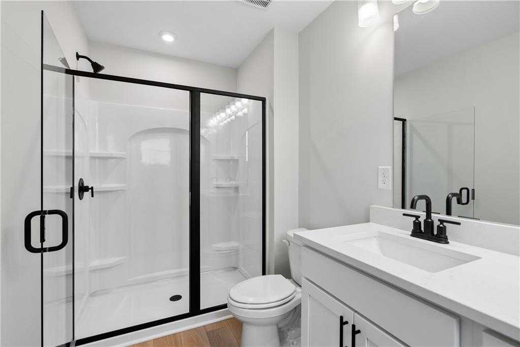 Modern bathroom with frameless glass walk-in shower, white subway tiles, and sleek vanity in Davidson Homes The Durant A, Emerson, Georgia