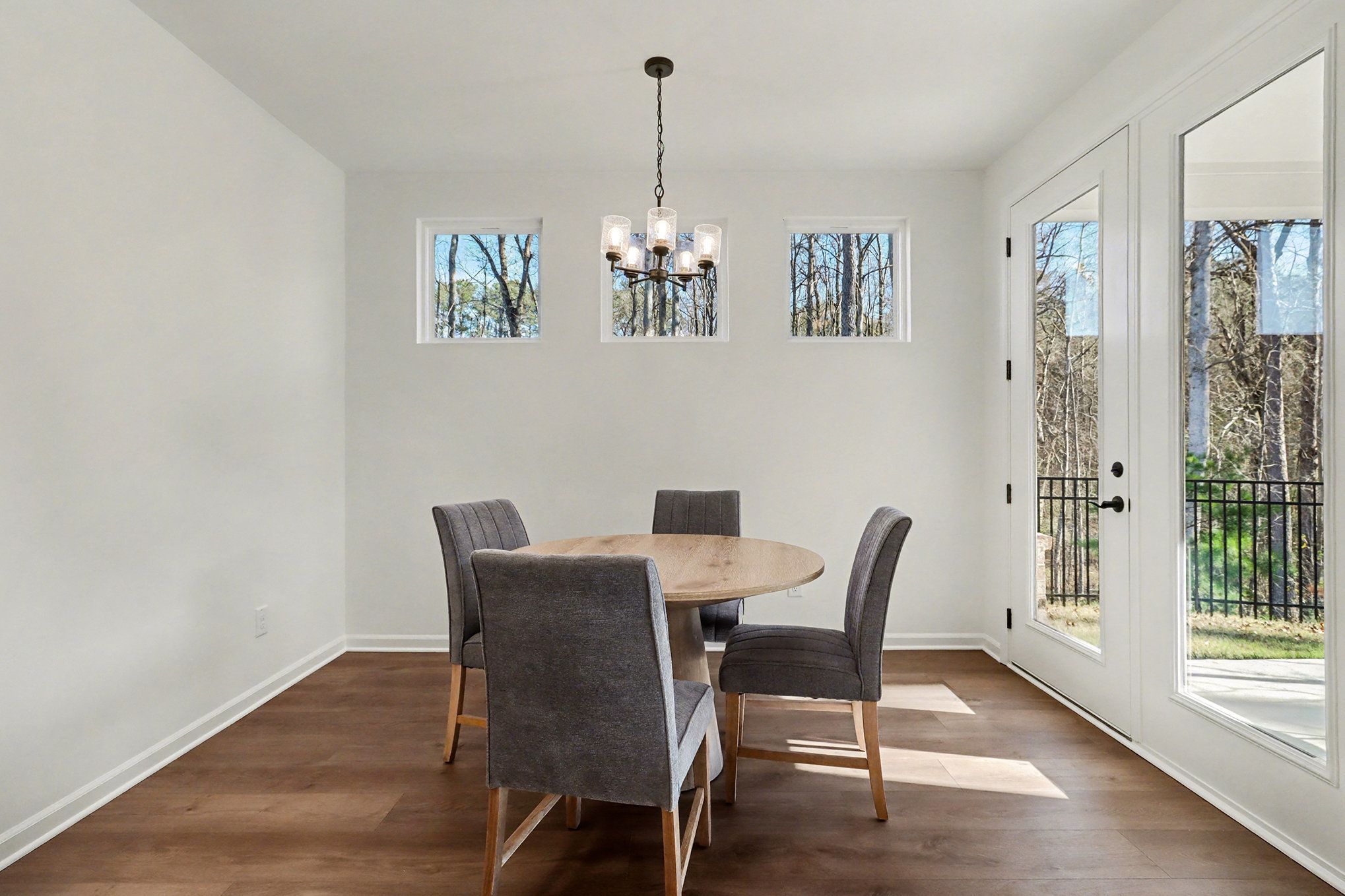 Open-concept dining room with round dining table, and hardwood floors in Davidson Homes The Daphne B, Loganville, GA