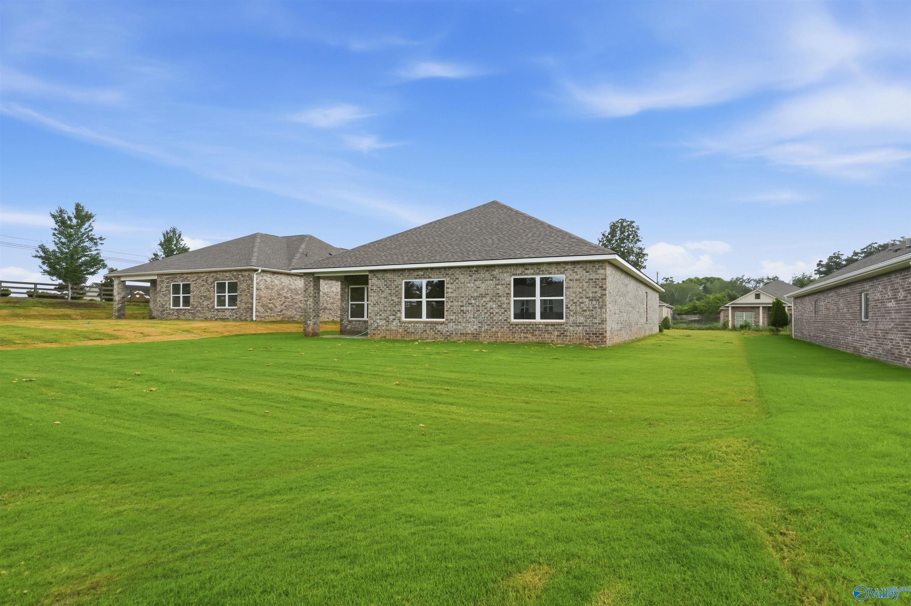 Rear view of a 1-story brick home by Davidson Homes, The Daphne C floor plan, in Flint Meadows, New Market, Alabama.
