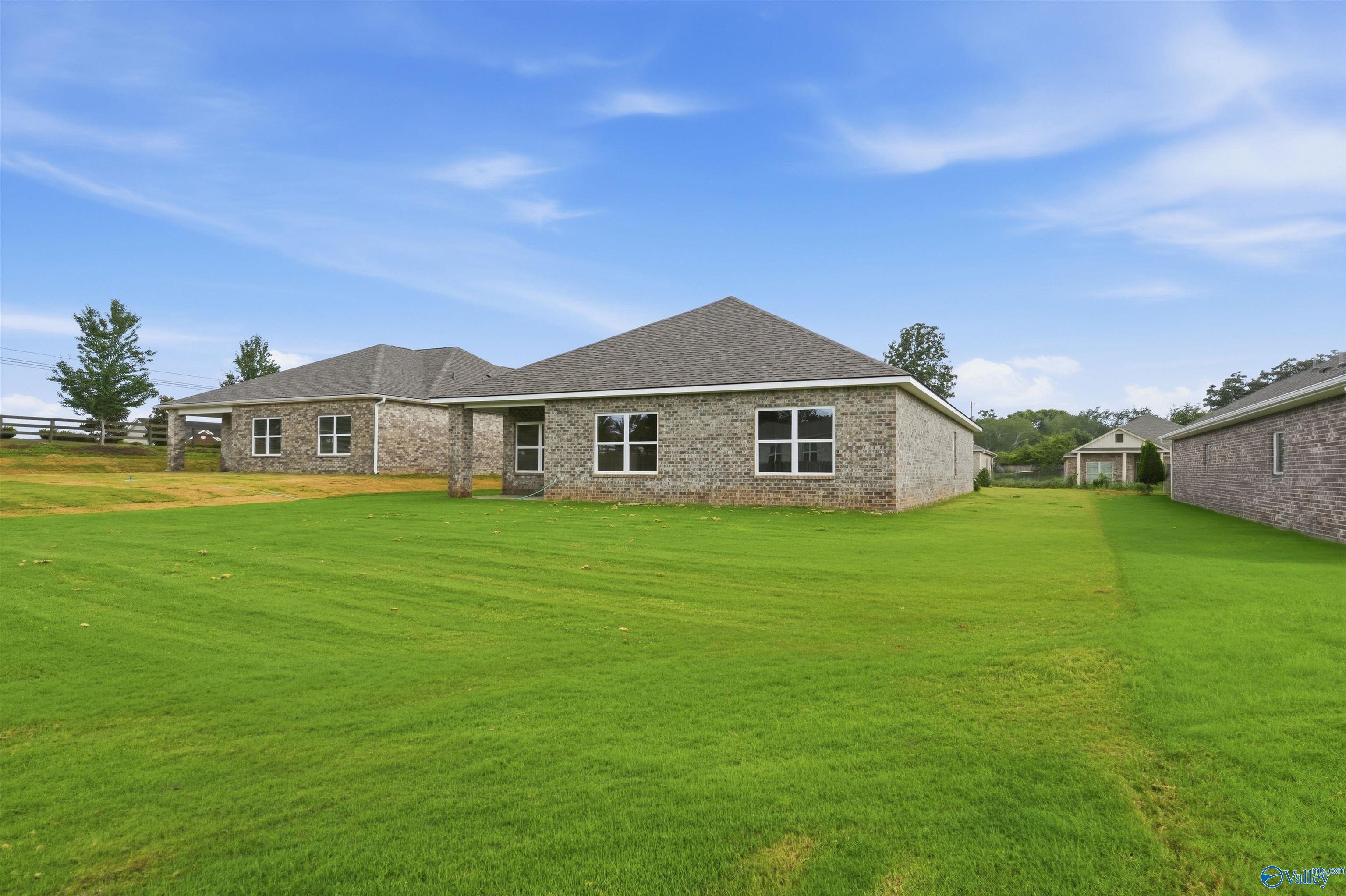 Rear view of a 1-story brick home by Davidson Homes, The Daphne C floor plan, in Flint Meadows, New Market, Alabama.