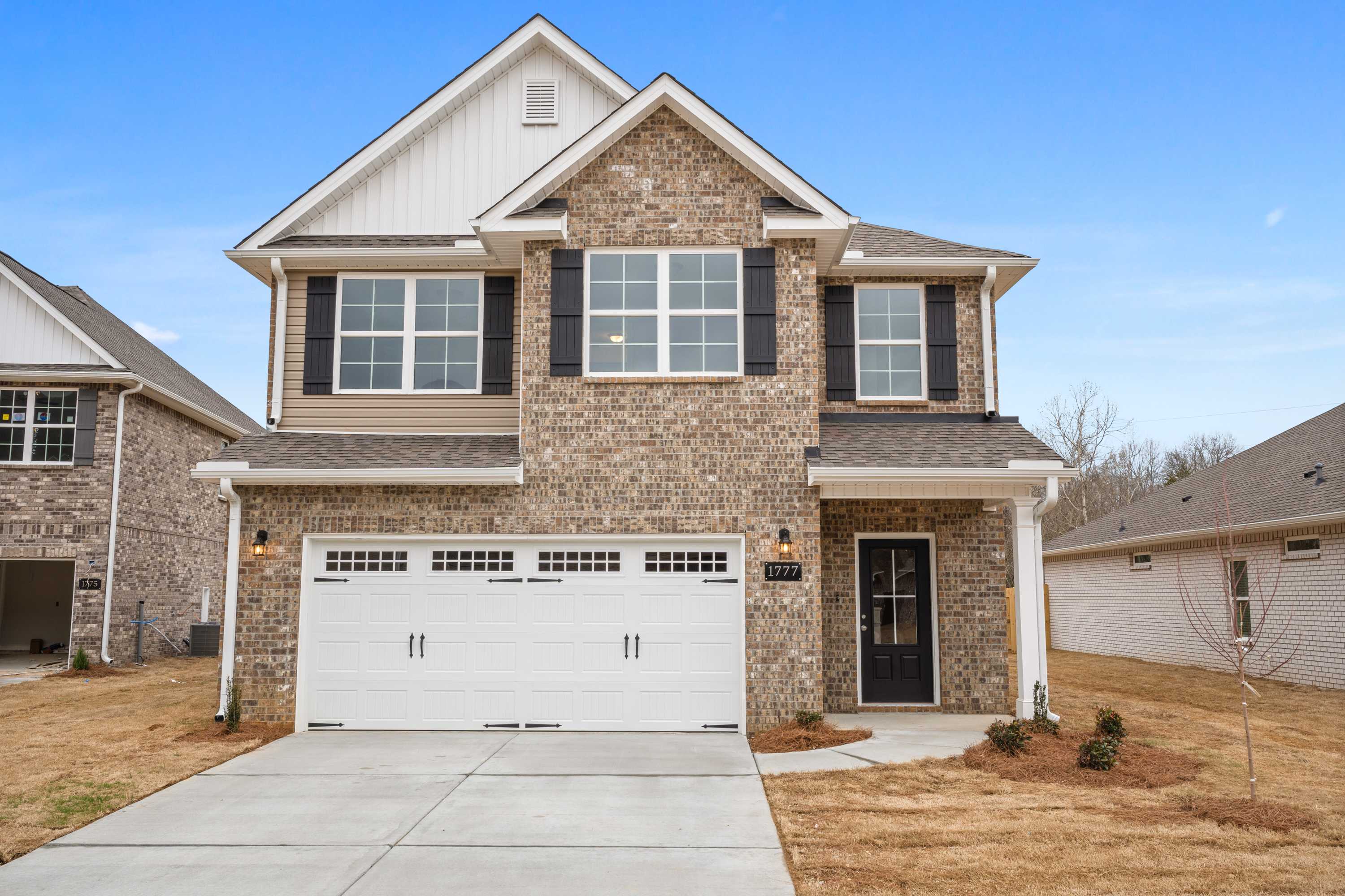 Two-story Aiken home elevation by Davidson Homes featuring brick and siding exterior, two-car garage, and front porch in Meridianville