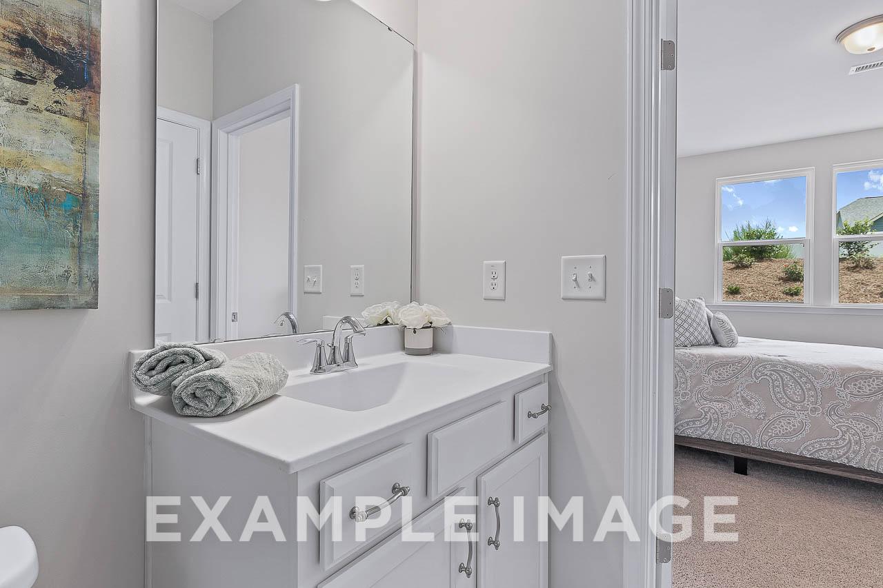 Master bathroom in The Willow C featuring white vanity sink, towels, and open view to adjacent bedroom