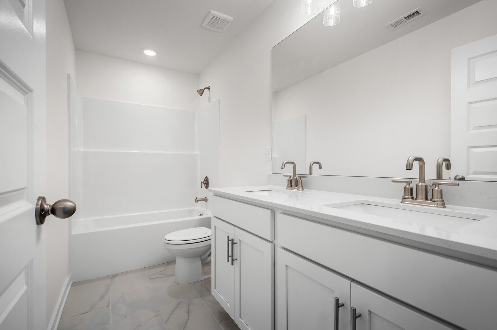 Modern secondary bathroom with double vanity and tub-shower combo in The Logan C floor plan at Calista Farms.