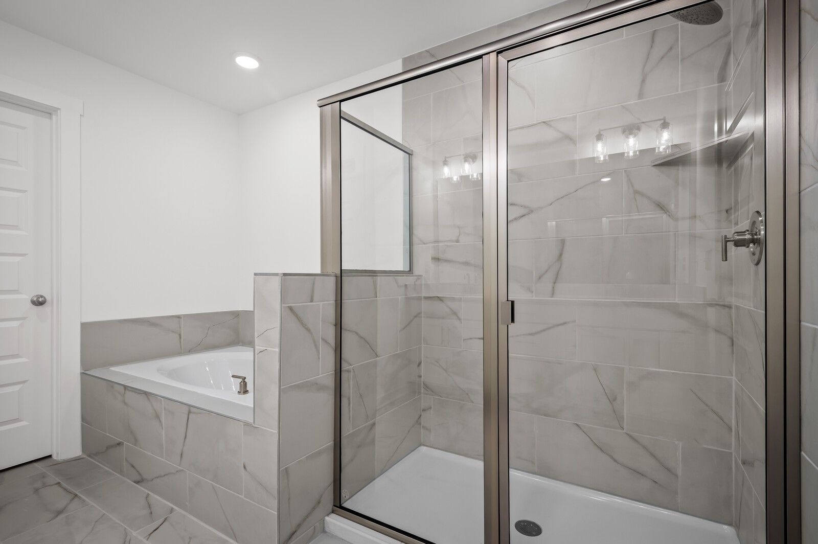 Modern master bathroom with tiled walk-in shower and soaking tub in The Logan C floor plan at Calista Farms, White House, TN.