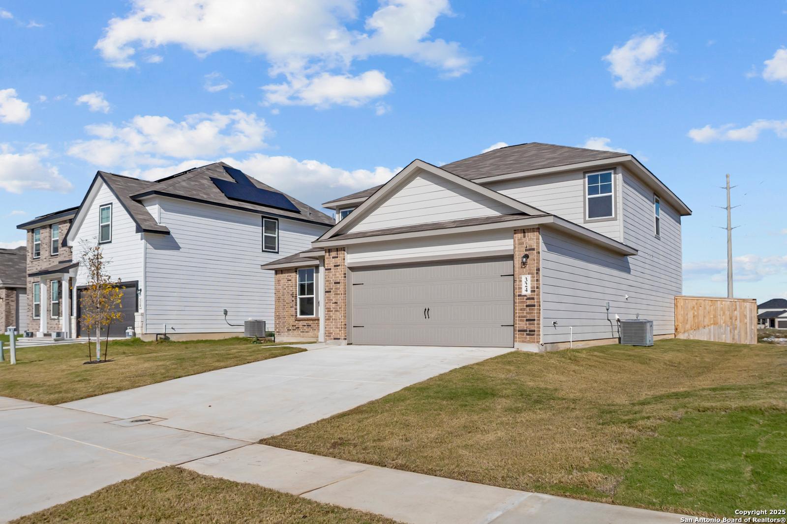 Two-story Davidson Homes Douglas C with 2-car garage, brick accents, and driveway in Hannah Heights, Seguin, Texas