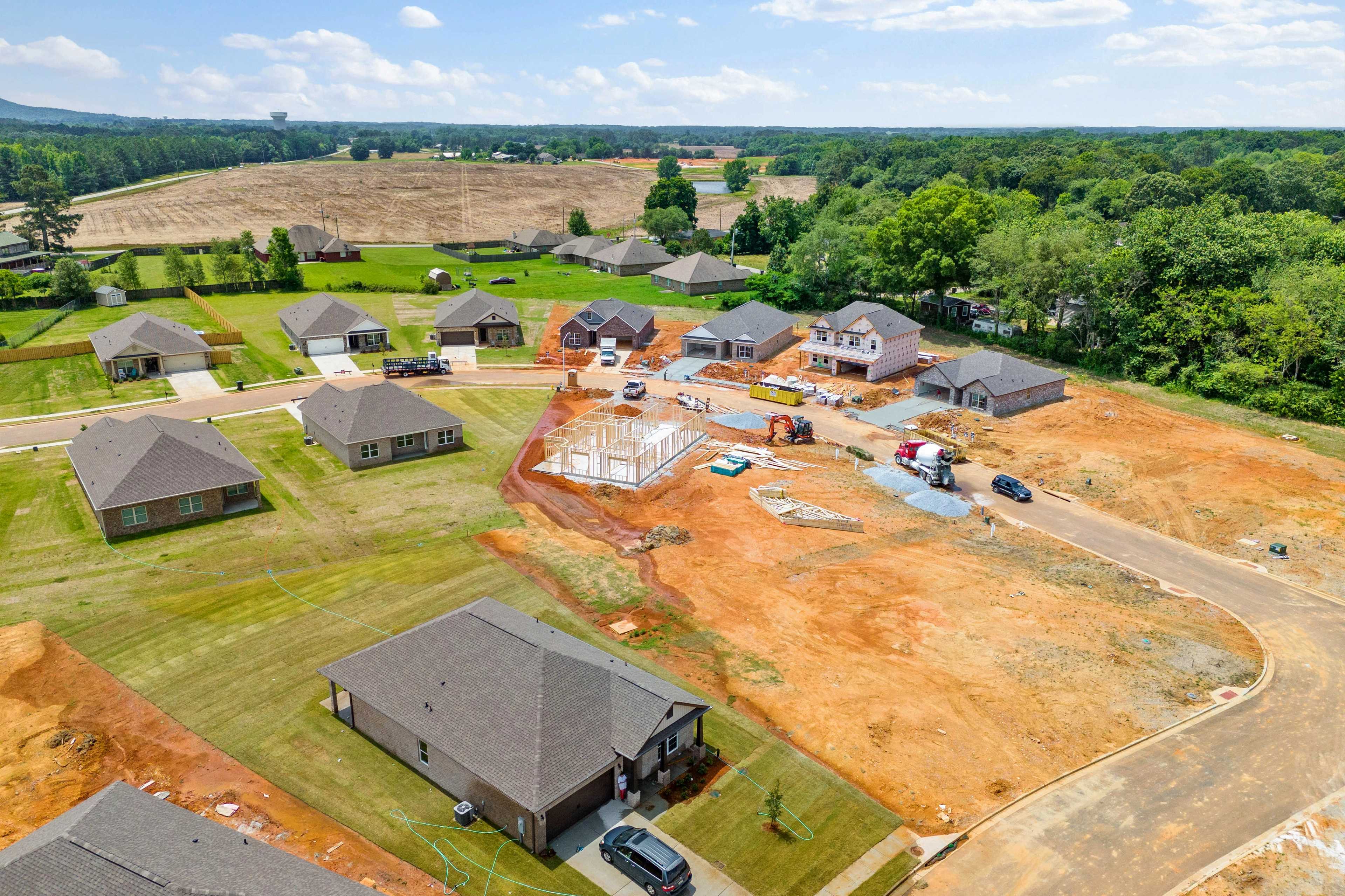 Aerial view of Durham Farms neighborhood in Harvest Alabama with new single-story homes under construction by Davidson Homes amid green fields