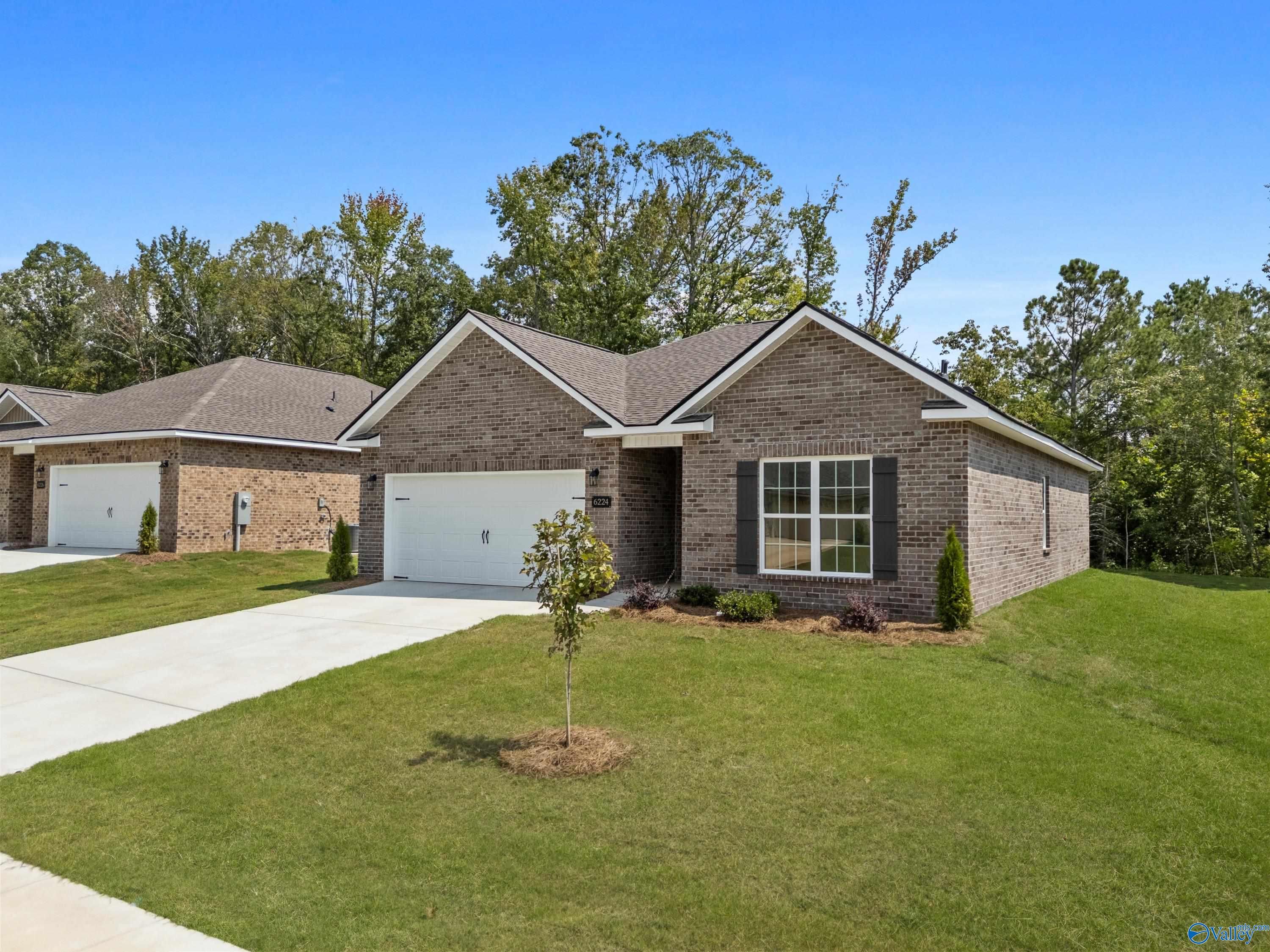 Brick single-story home with 2-car garage, driveway, and lush front yard in Spragins Cove, Huntsville, Alabama by Davidson Homes The Asheville