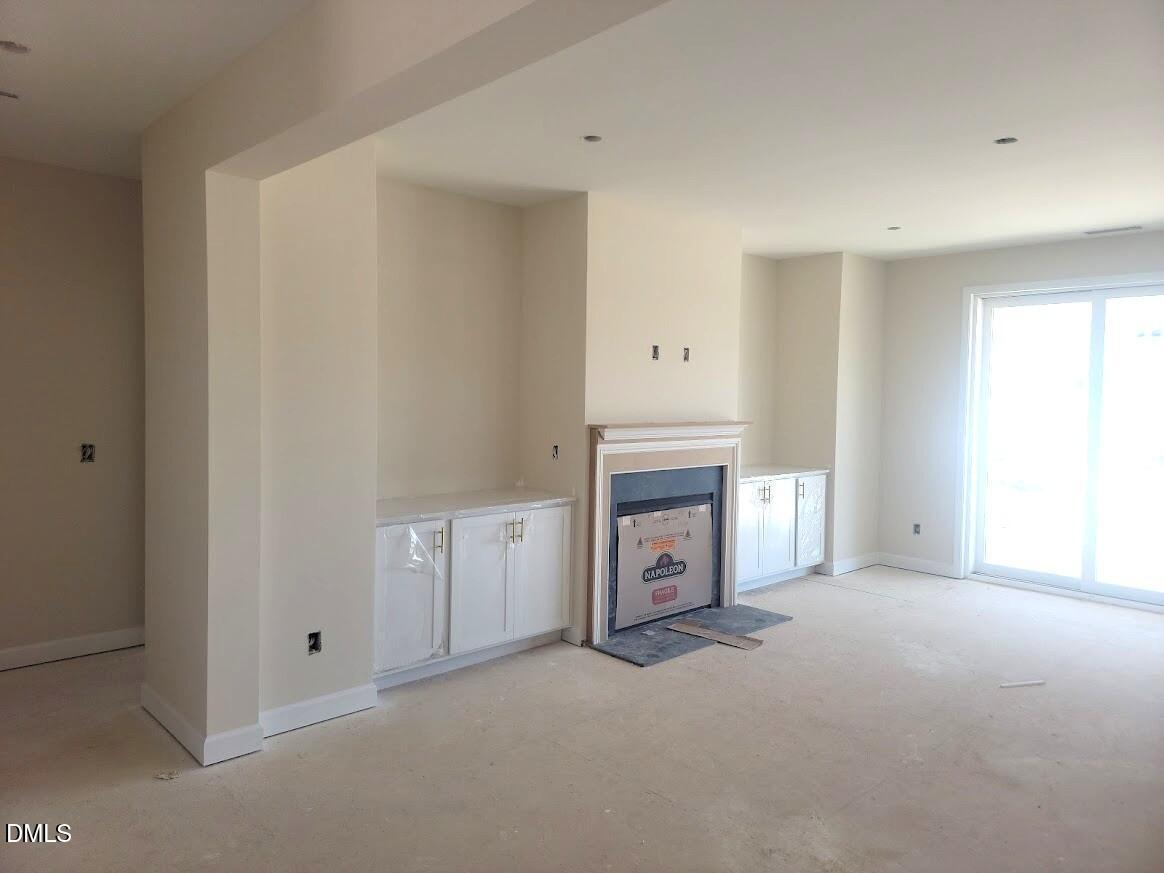 Elegant family room with fireplace, built-in cabinets, and sliding glass doors in Davidson Homes The Cypress B II, Angier NC