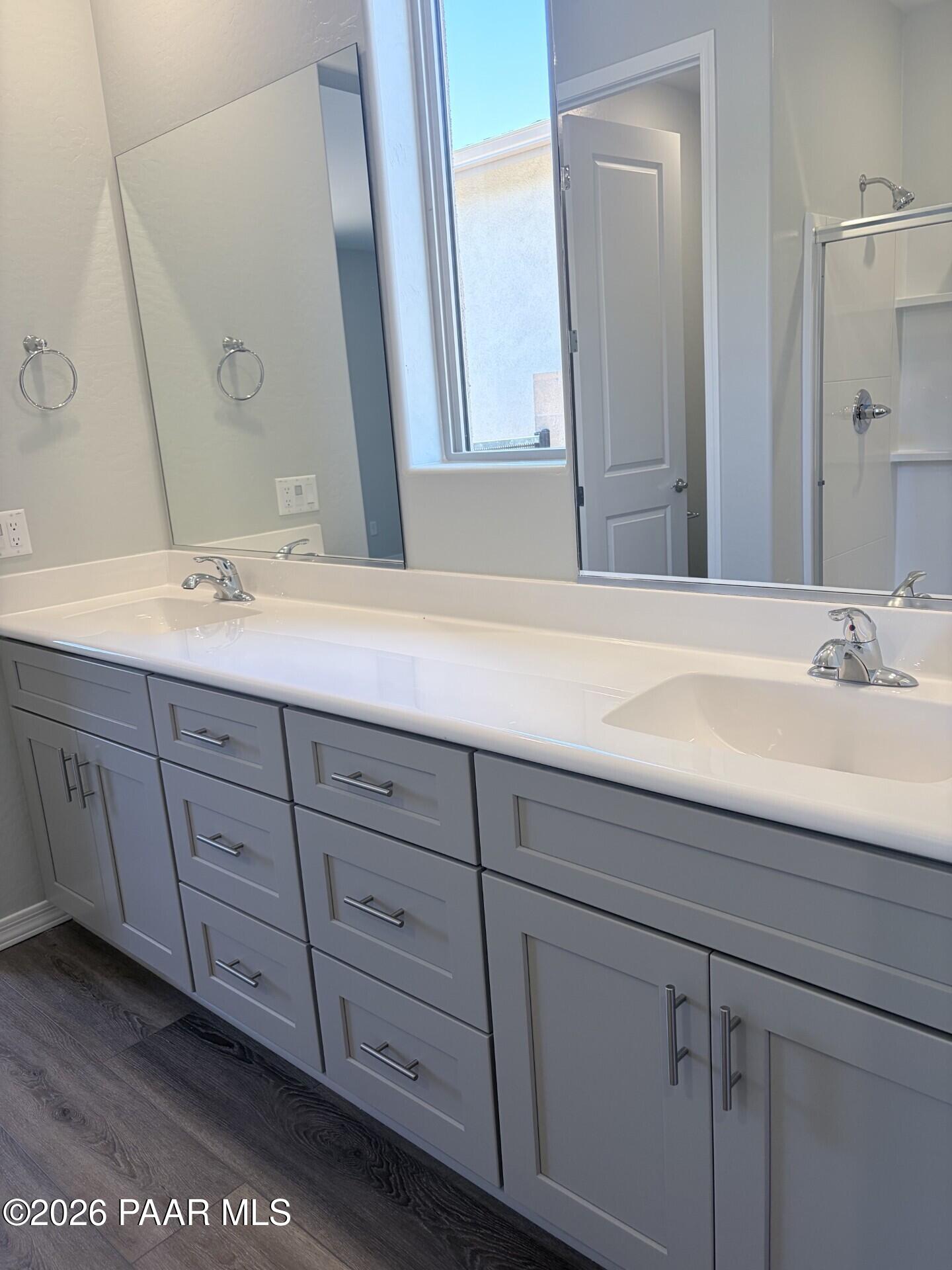 Modern double vanity with gray cabinets and white countertop in The Frontier A bathroom at North Ridge, Prescott Valley.