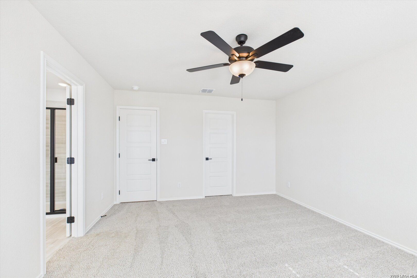 Spacious bedroom with ceiling fan, carpet floor, bathroom and closet doors in Davidson Homes The Gillian B, San Antonio, Texas