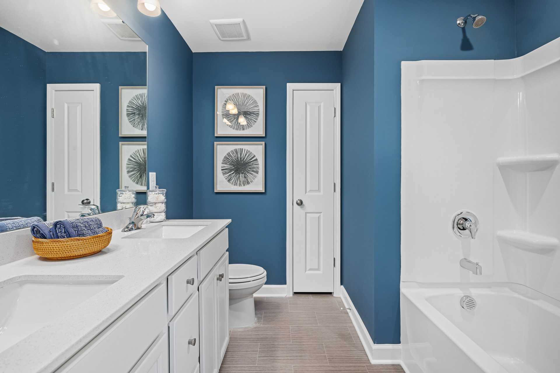 Modern bathroom at Beverly Place in Four Oaks, NC with navy blue walls, double vanity, and soaking tub