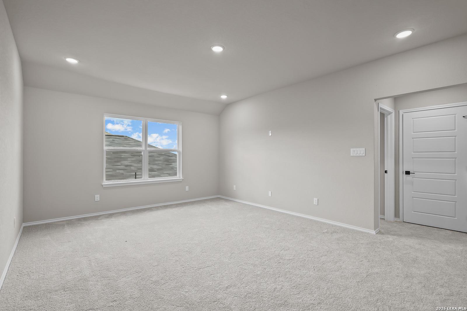 Spacious empty bedroom with carpet flooring, recessed lighting, and large window in Davidson Homes The Sequoia C, Royal Crest San Antonio