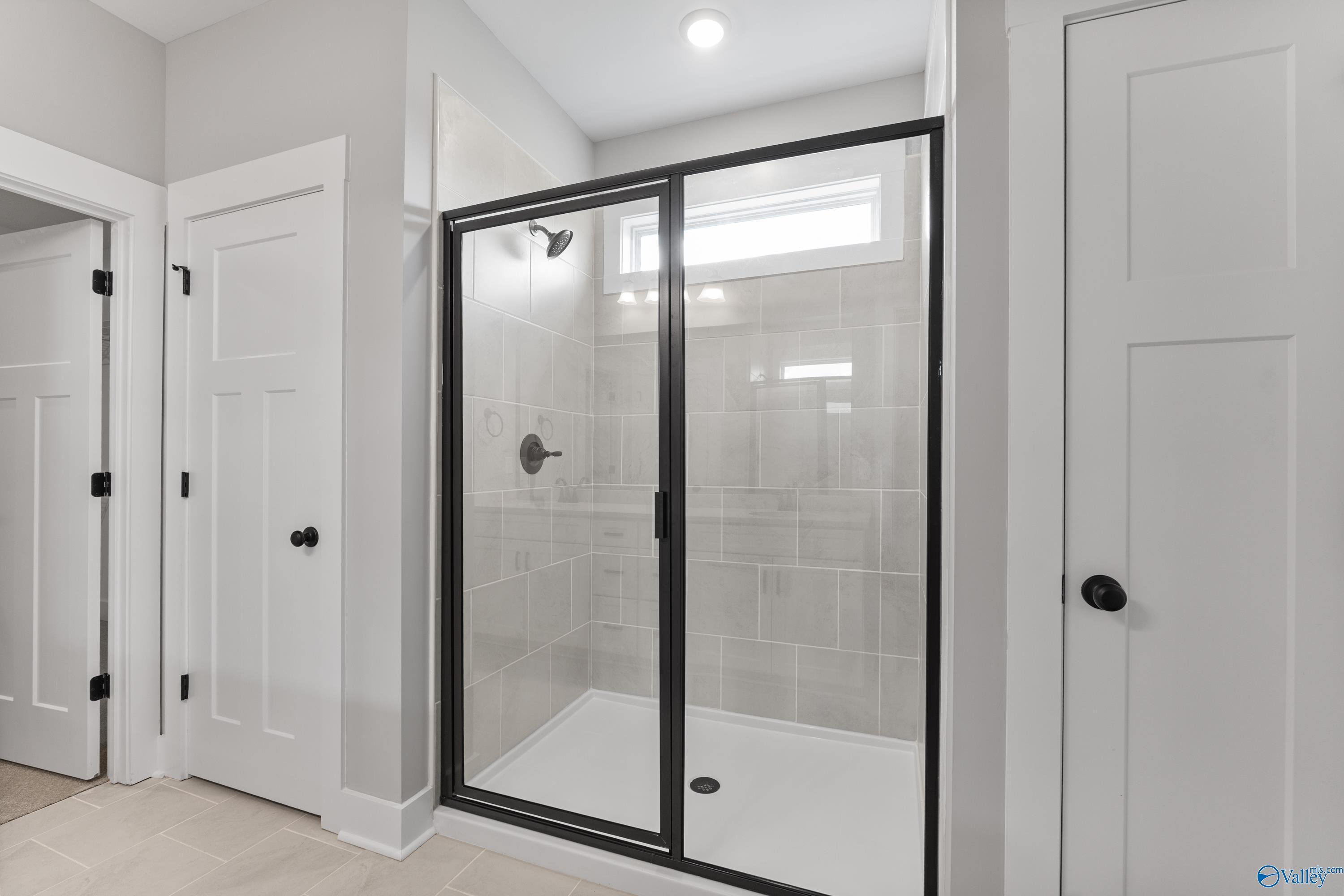 Modern frameless glass shower with subway tile walls in master bathroom, Davidson Homes The Arcadia, Huntsville AL