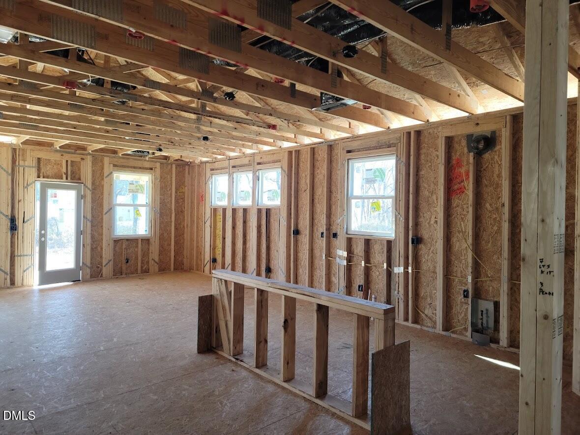Spacious framed interior with exposed wooden beams, large windows, and electrical wiring in Davidson Homes Ashport G, Angier, NC