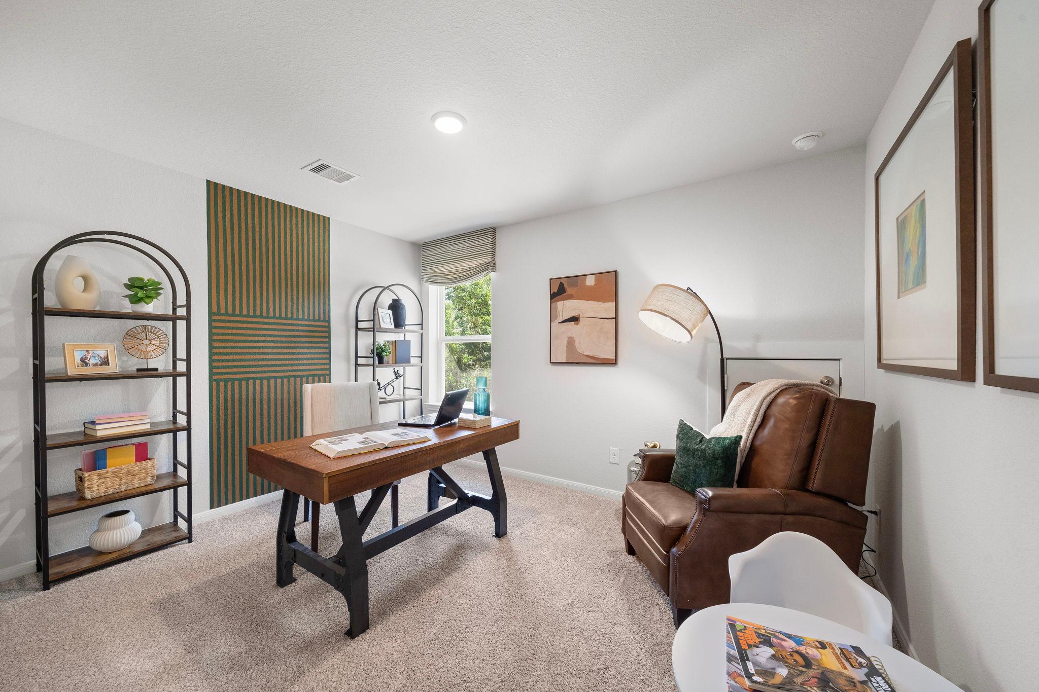 Cozy home office at Caney Creek Place in Conroe TX featuring rustic wooden desk, green accent wall, bookshelves, leather armchair