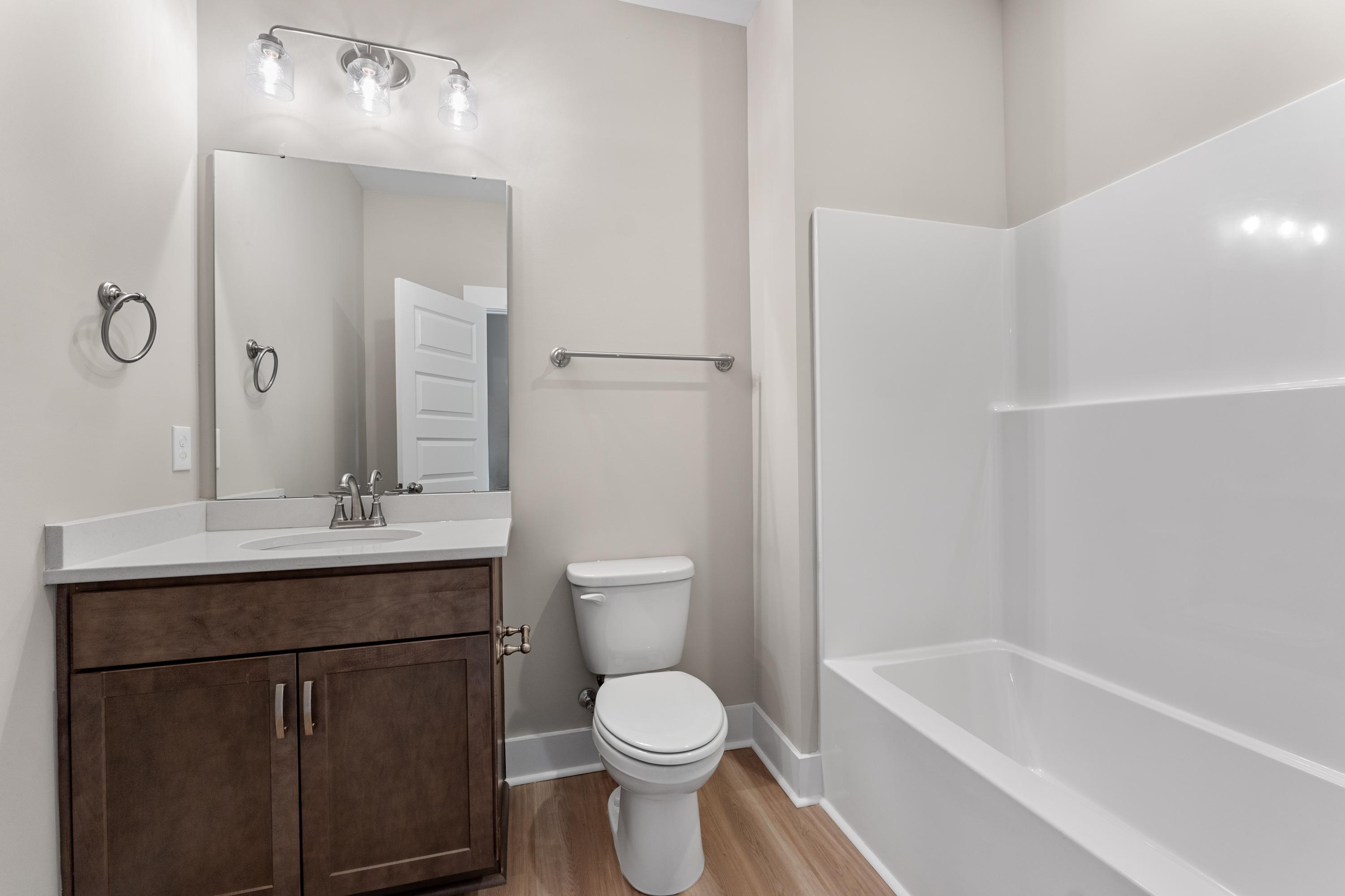 The Oxford master bathroom featuring shaker vanity, single sink, walk-in shower, soaking tub, and neutral tones