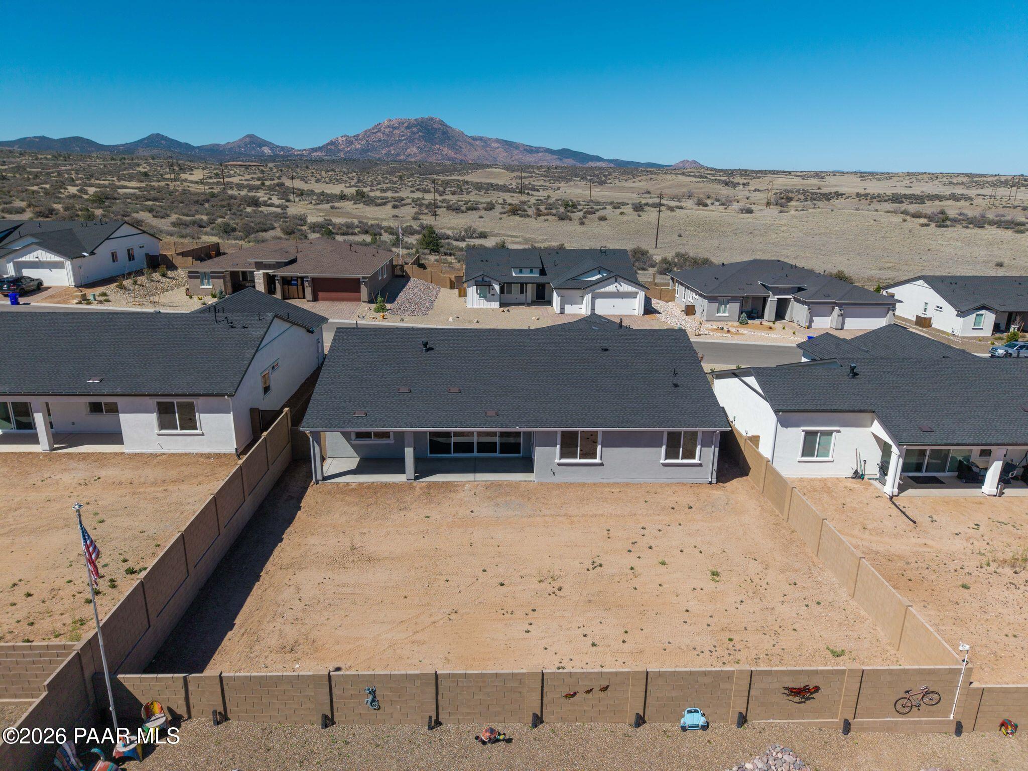 Aerial view of The Monarch A single-story home by Davidson Homes in Westwood, Prescott AZ, with 3-car garage, fenced yard, and desert mountains