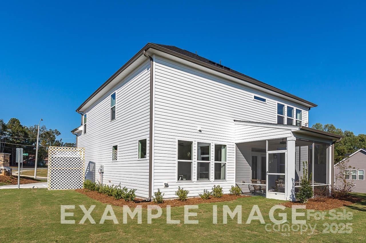 Two-story white-sided Davidson Homes The Hemlock A exterior with 2-car garage, screened porch, and landscaped yard in Enclave at Belmont, NC