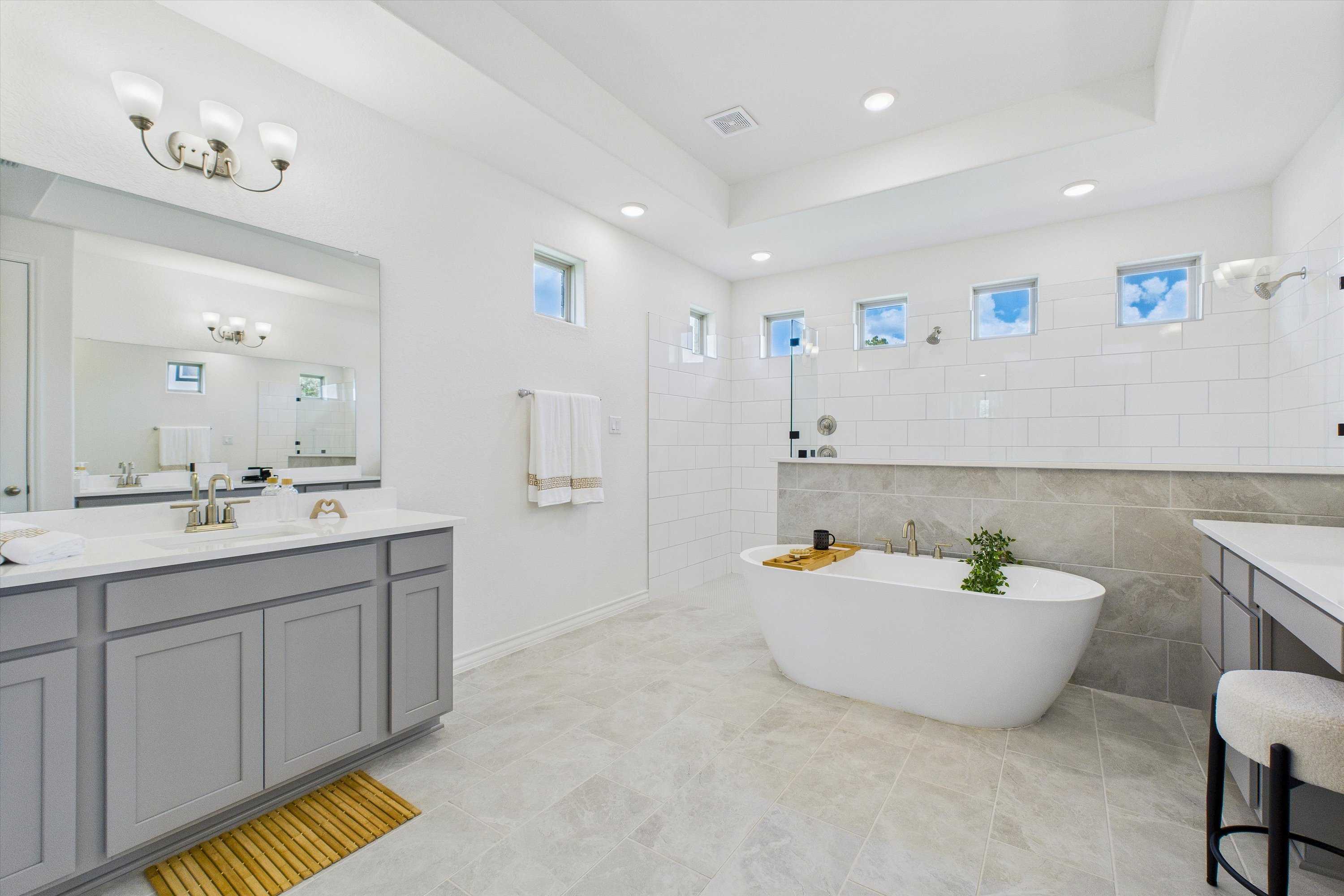 Luxurious master bathroom featuring freestanding tub, double gray vanity, walk-in shower in Davidson Homes The Summerlin C, Castroville, Texas