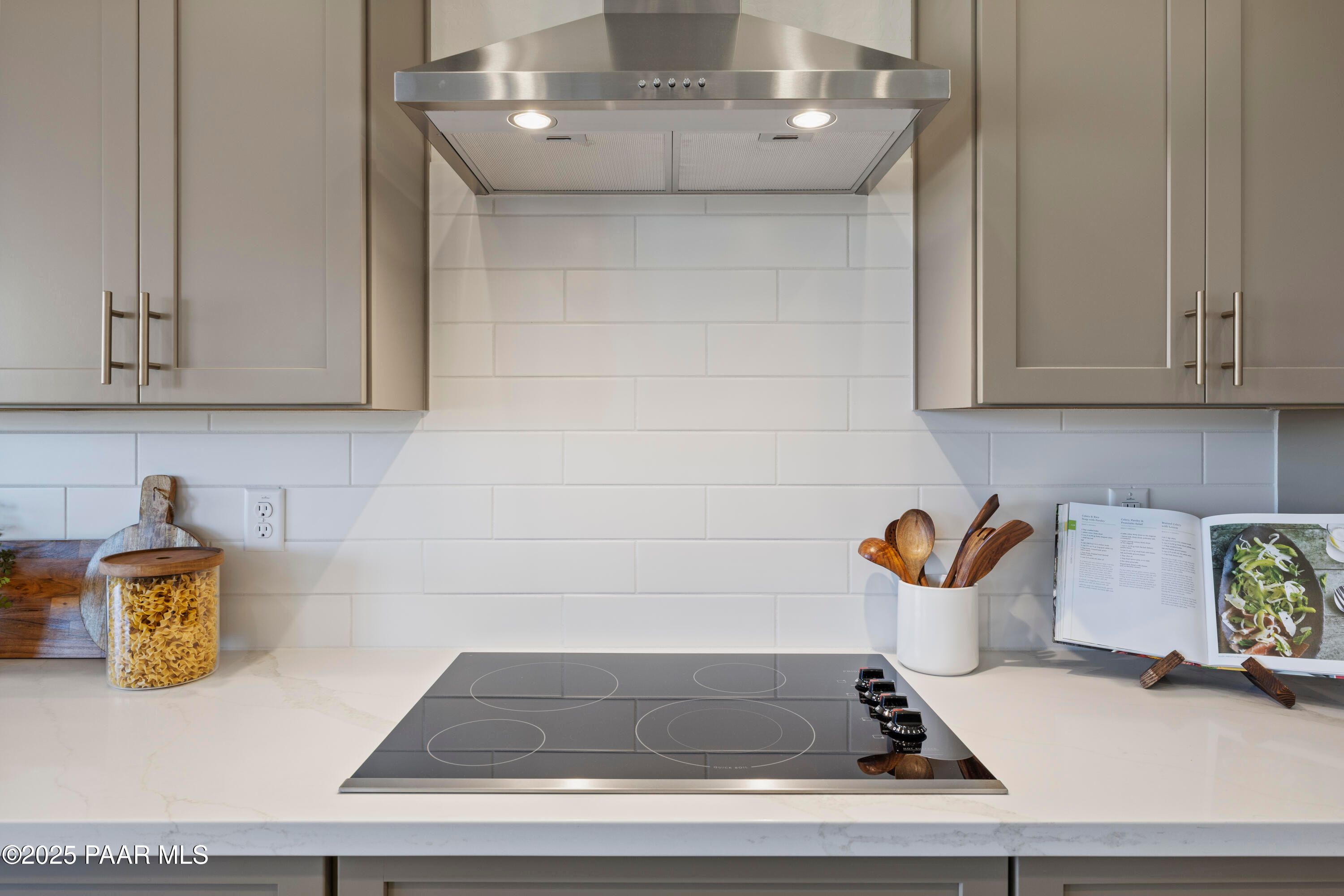 Modern kitchen with induction cooktop, stainless hood, subway tile backsplash in Davidson Homes The Blaze D, Prescott AZ