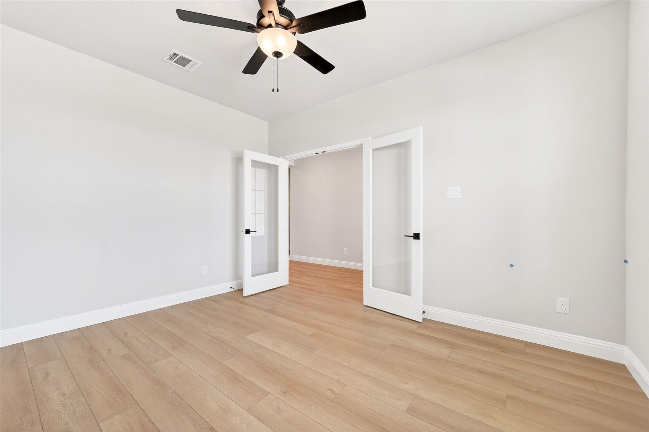 Bright flex room with French doors and ceiling fan in The Holly C floor plan at Parks at Foster Crossing, Anna, Texas.