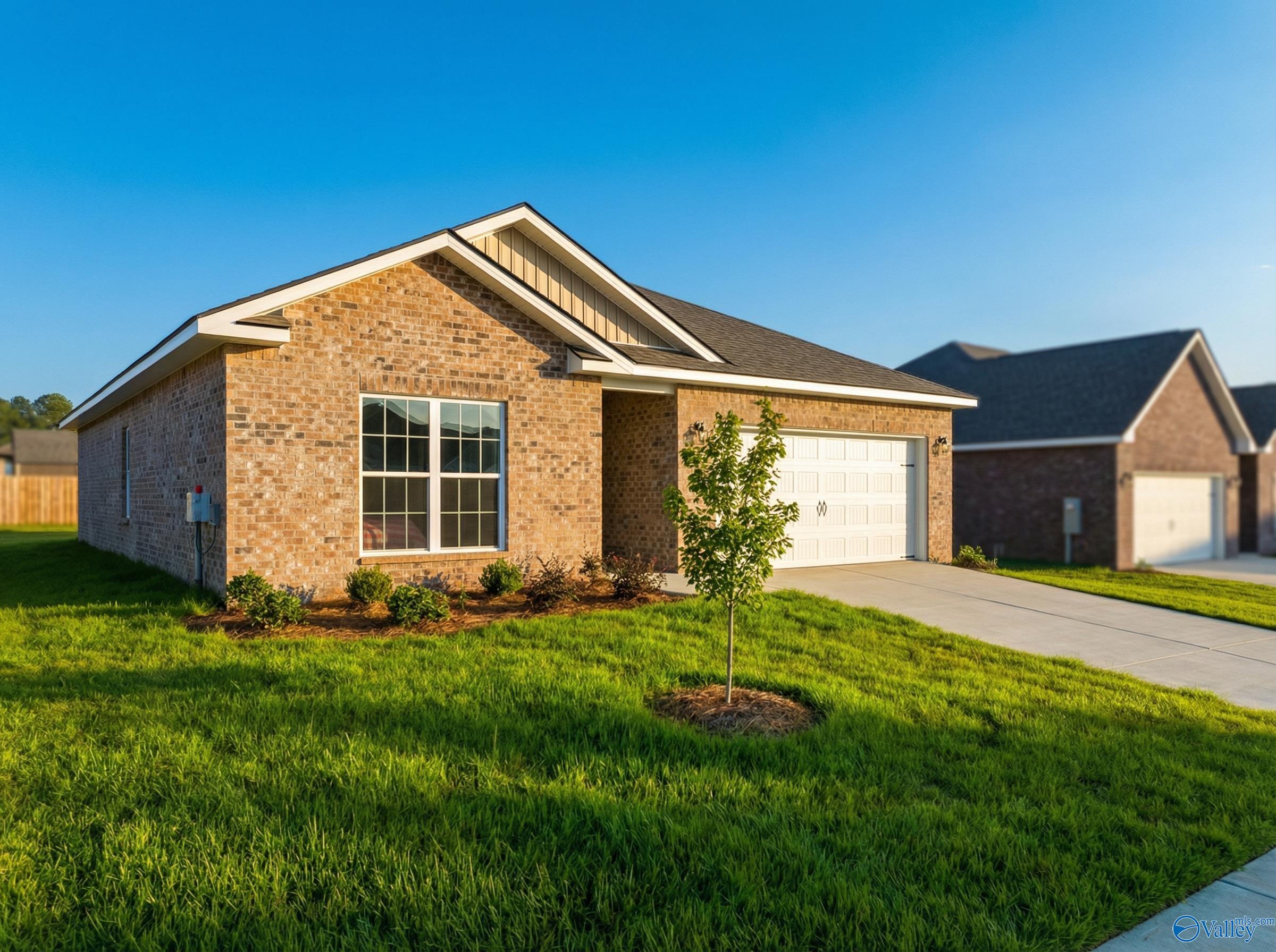 Brick single-story home with 2-car garage, large windows, and lush green lawn in Wood Trail, Toney, Alabama - Davidson Homes The Asheville