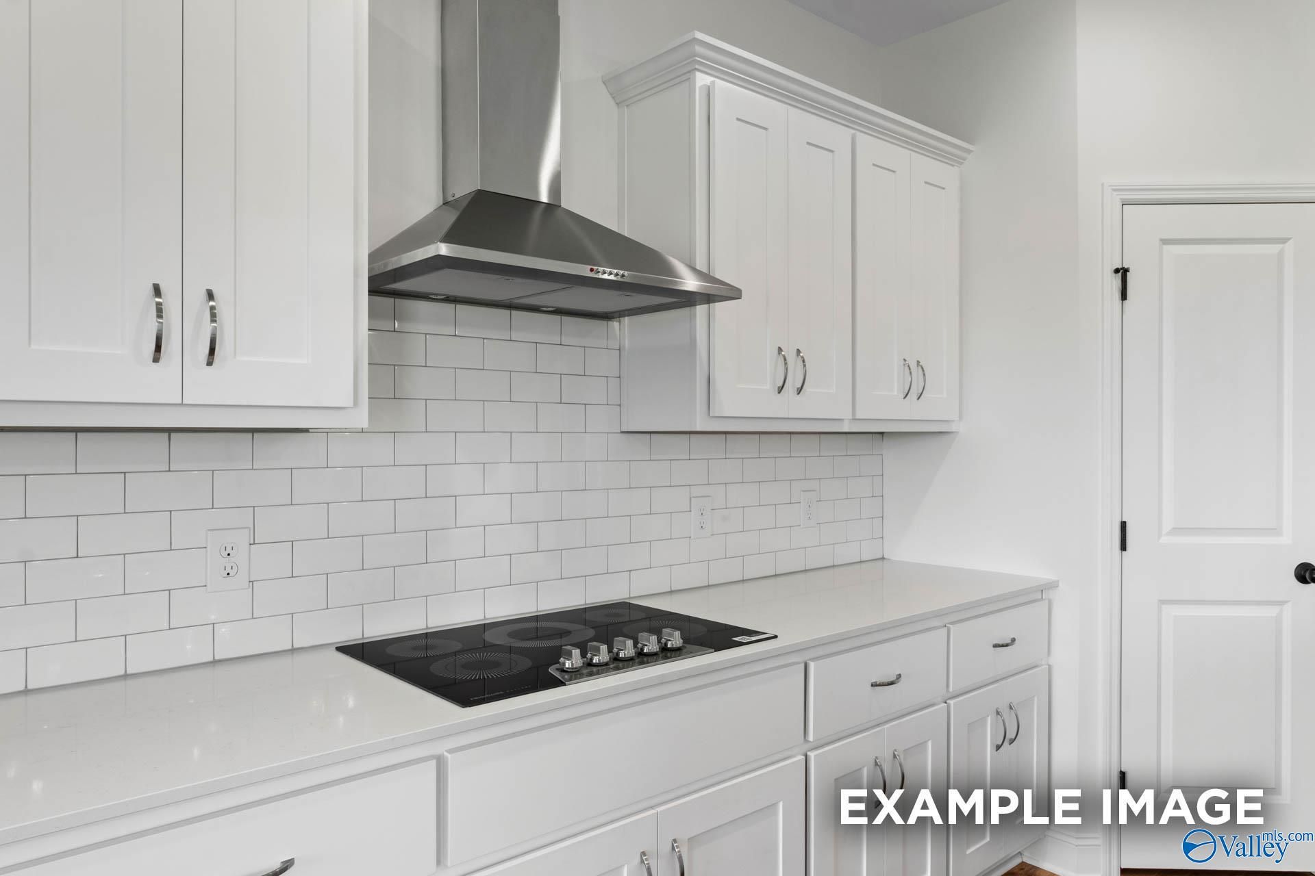 Modern kitchen with white shaker cabinets, subway tile backsplash, and stainless steel range hood in Briercreek home.