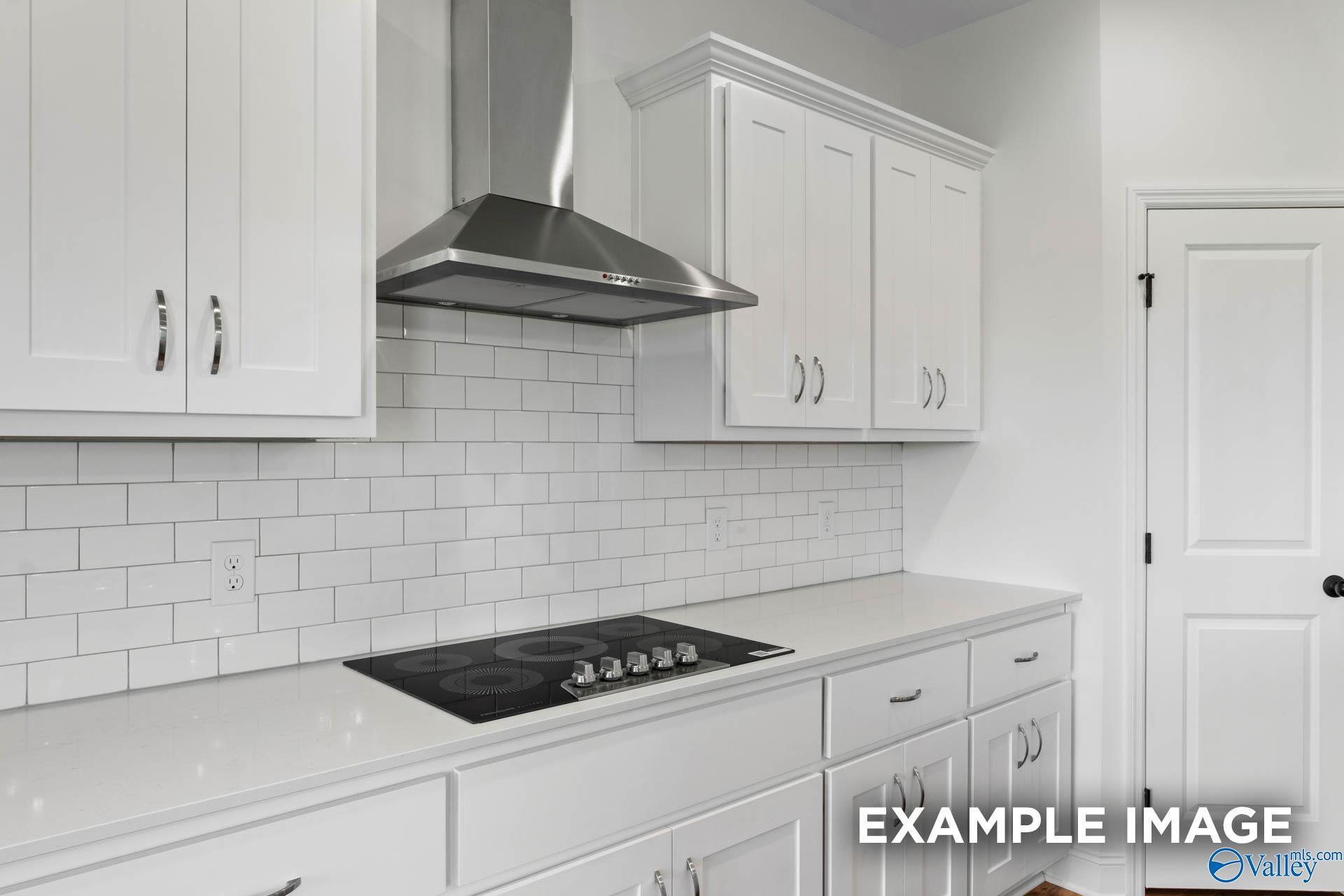 Modern kitchen with white shaker cabinets, subway tile backsplash, and stainless steel range hood in Briercreek home.